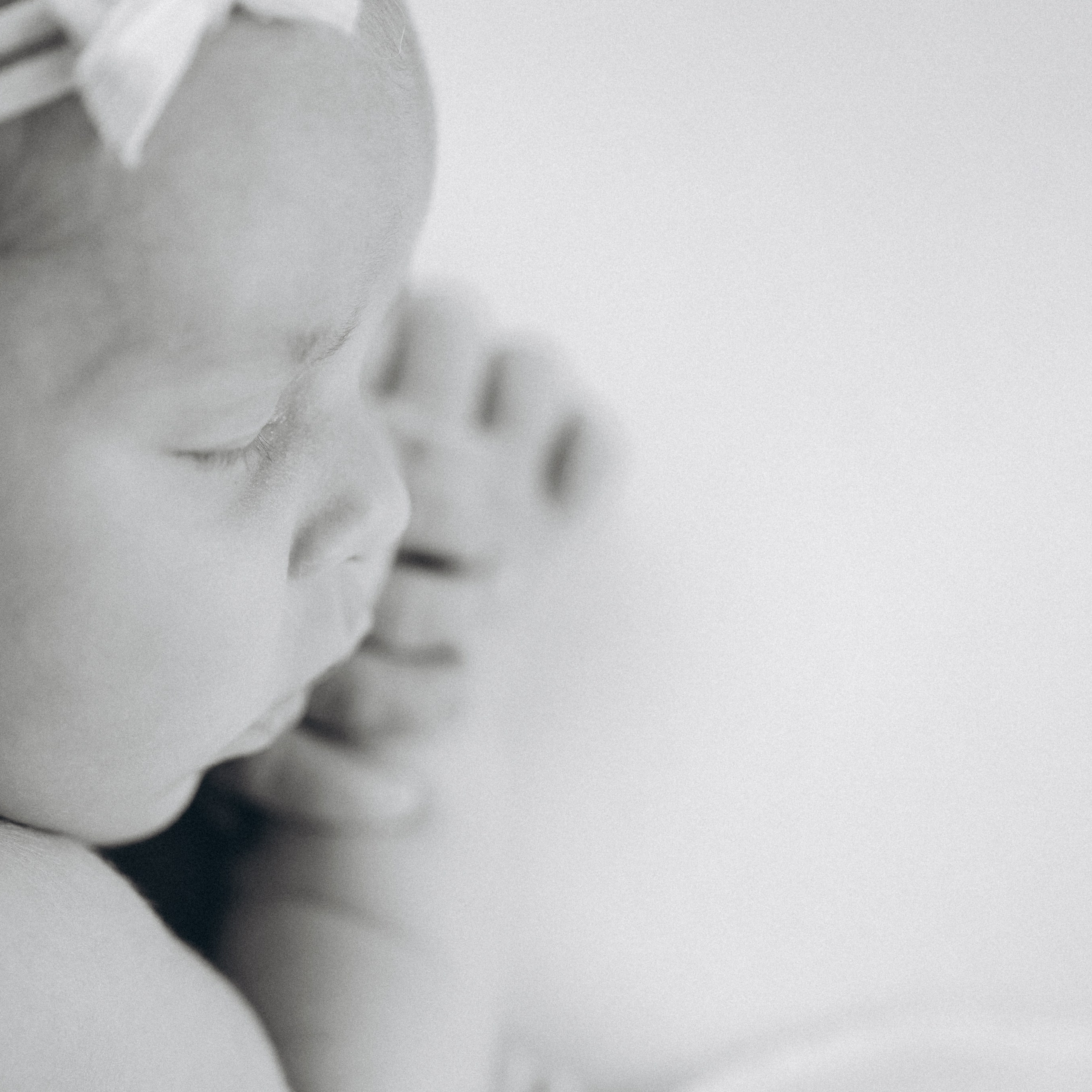 Close up von einem neugeborenen Mädchen mit der Schleife am Kopf.