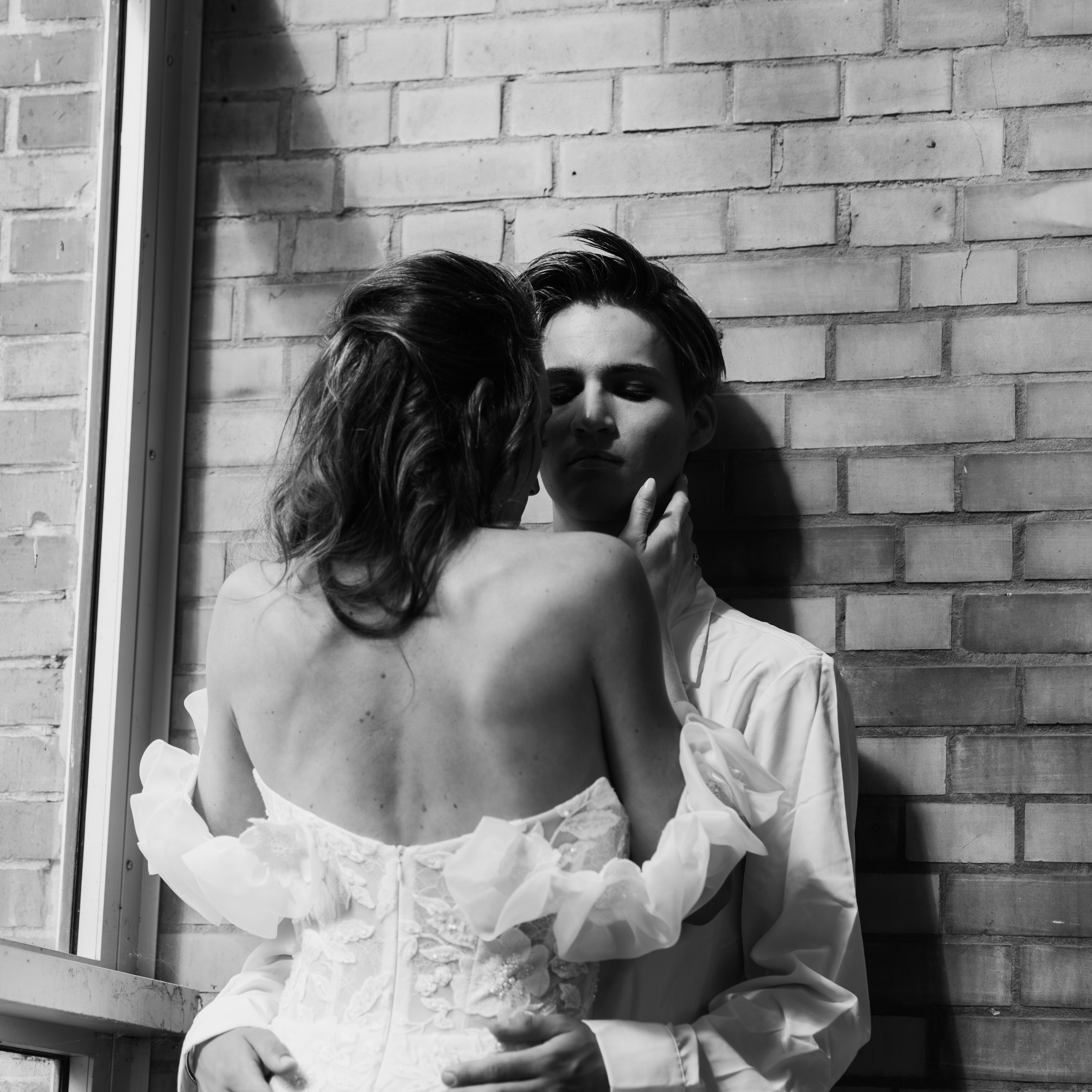 Stijlvolle huwelijksfoto van bruid in witte jurk bij een oud industriepand - Kapture Fotografie