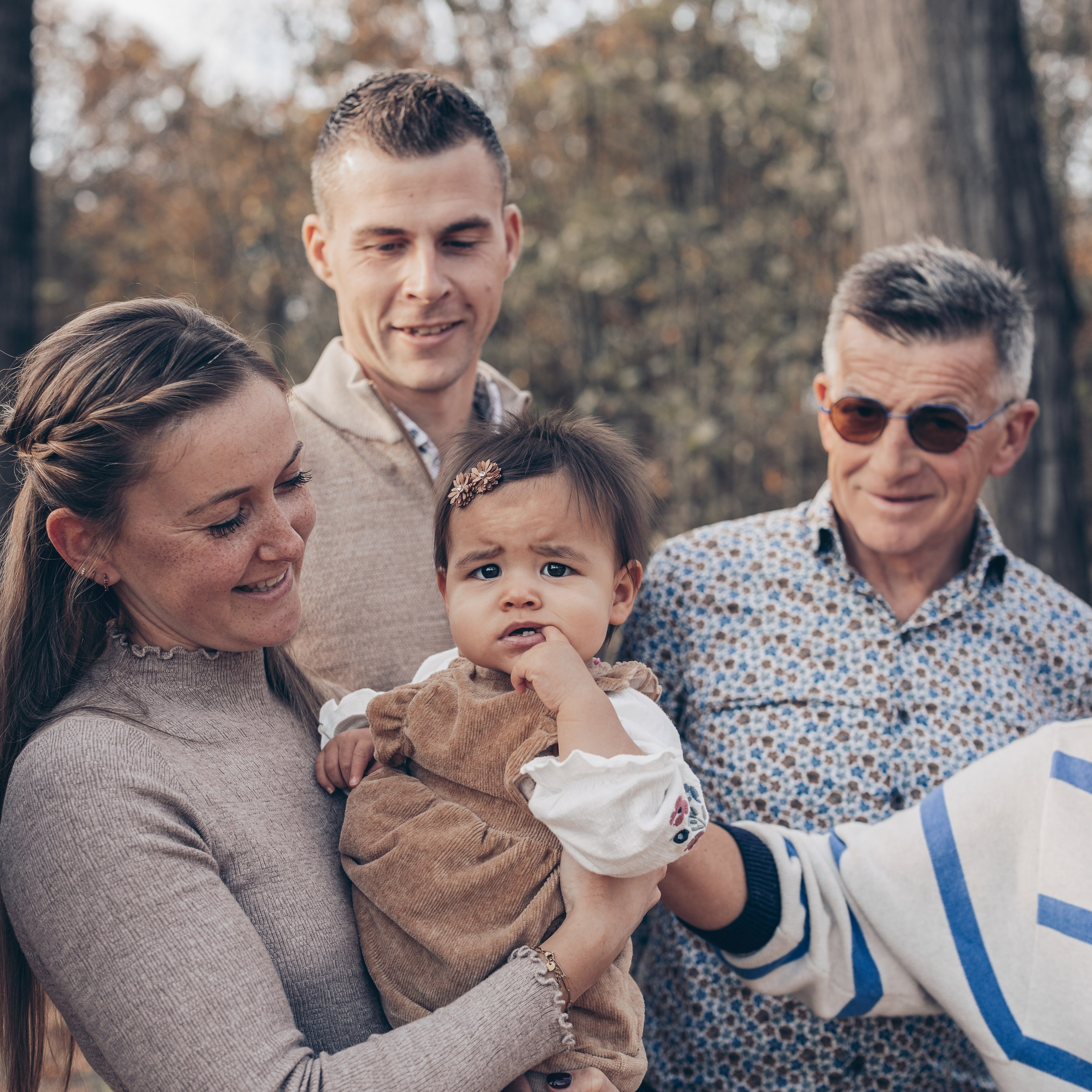 Familie poseert voor fotoshoot in bosrijk gebied tijdens de herfst - Kapture Fotografie