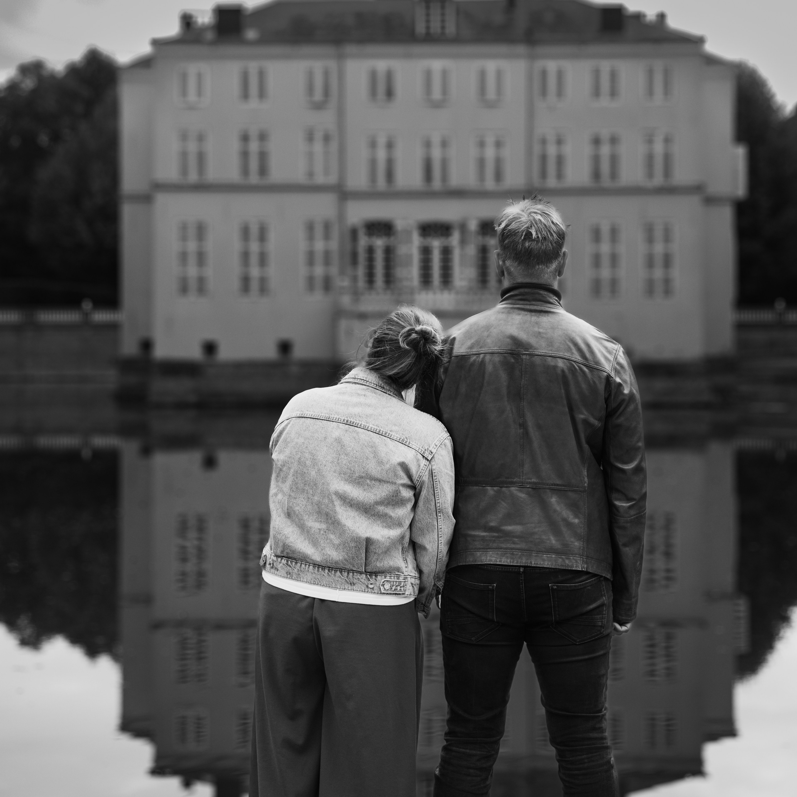 Koppel staat naast elkaar en kijkt naar kasteel met de rug naar de camera tijdens romantische fotoshoot door Kapture Fotografie