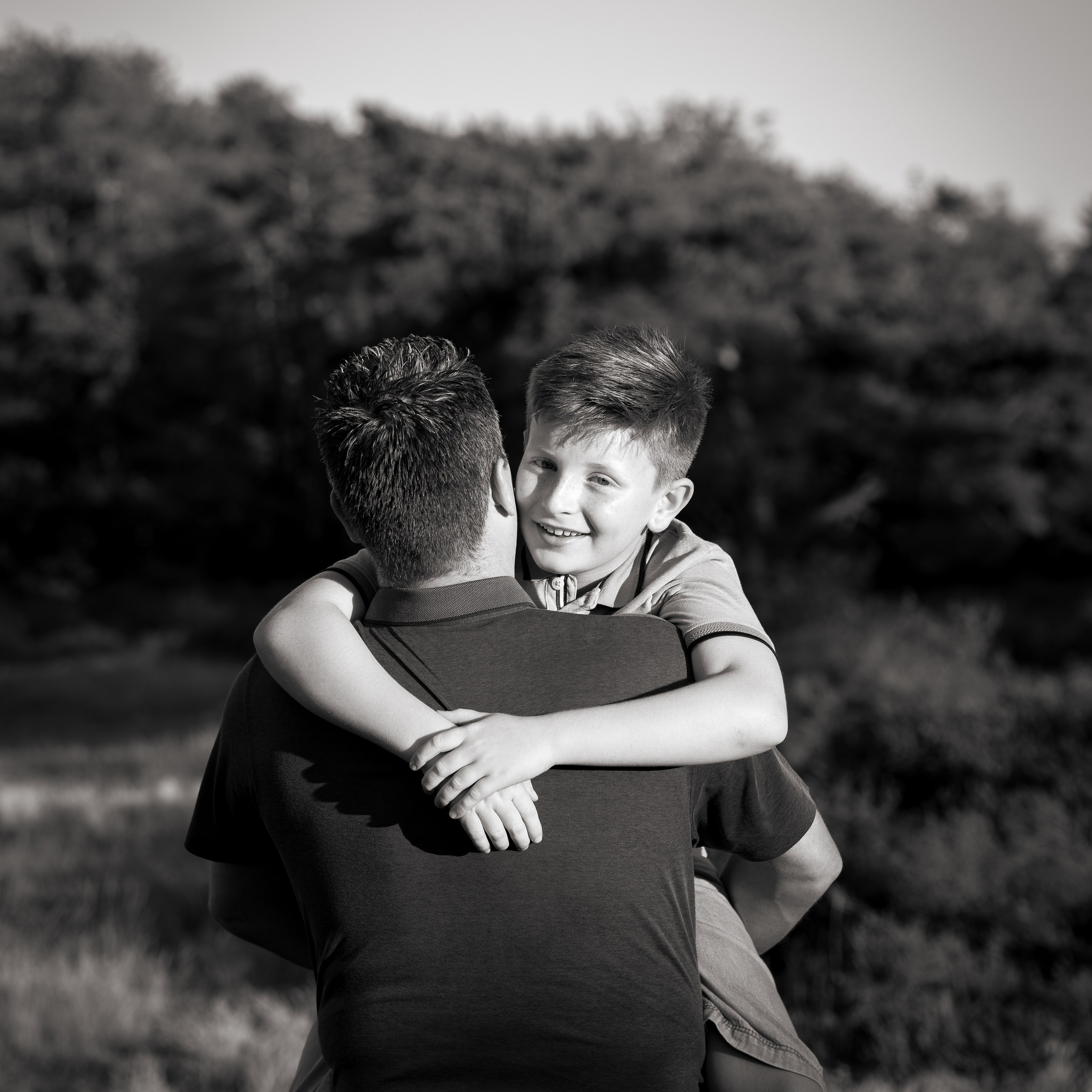 Vader en zoon delen een warme knuffel tijdens lifestyle fotosessie