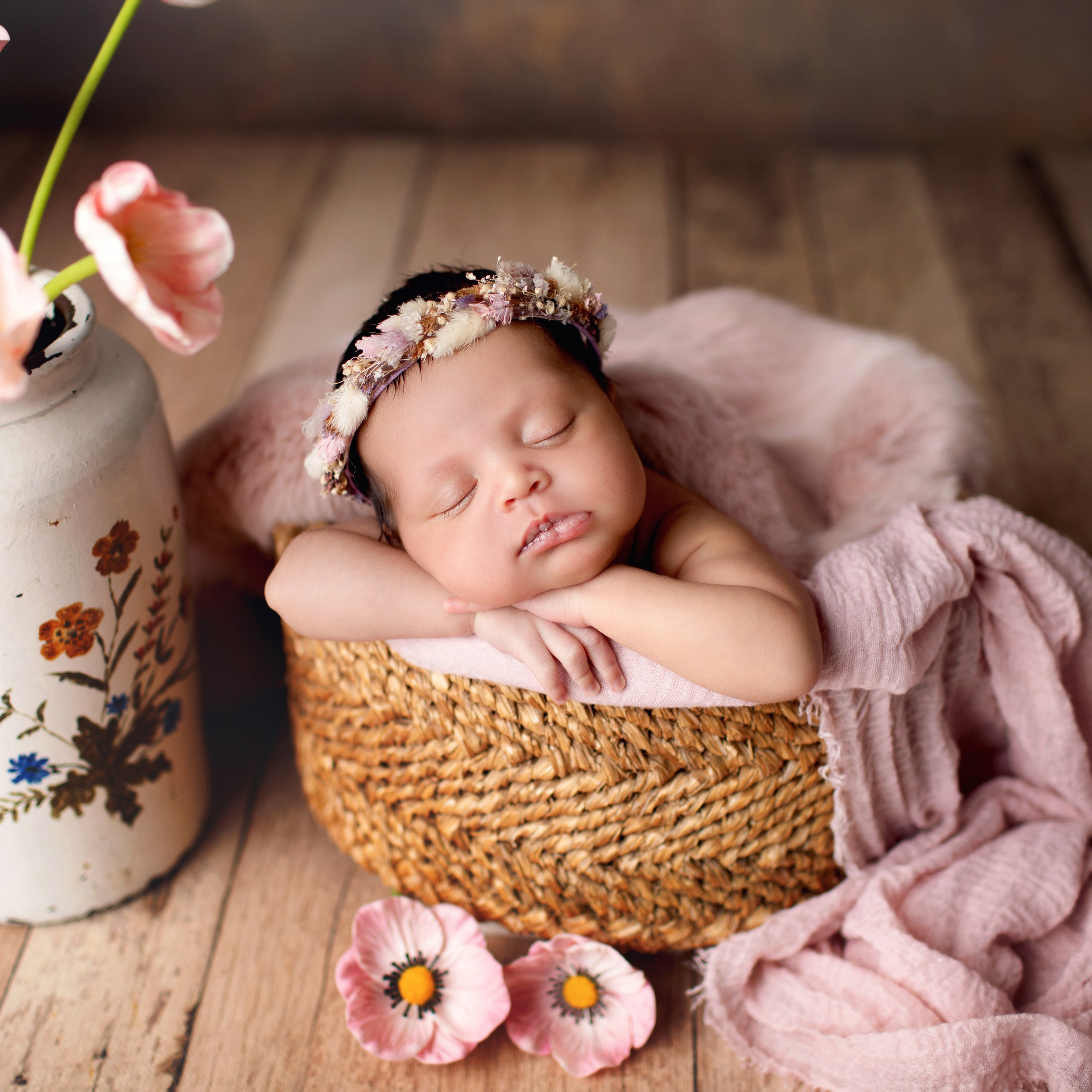 "Söt nyfödd baby som ligger i en mjuk filt med ett lugnt uttryck. Bilden är utmärkt för webbplatser som fokuserar på babyfotografi och nyfödda bilder."