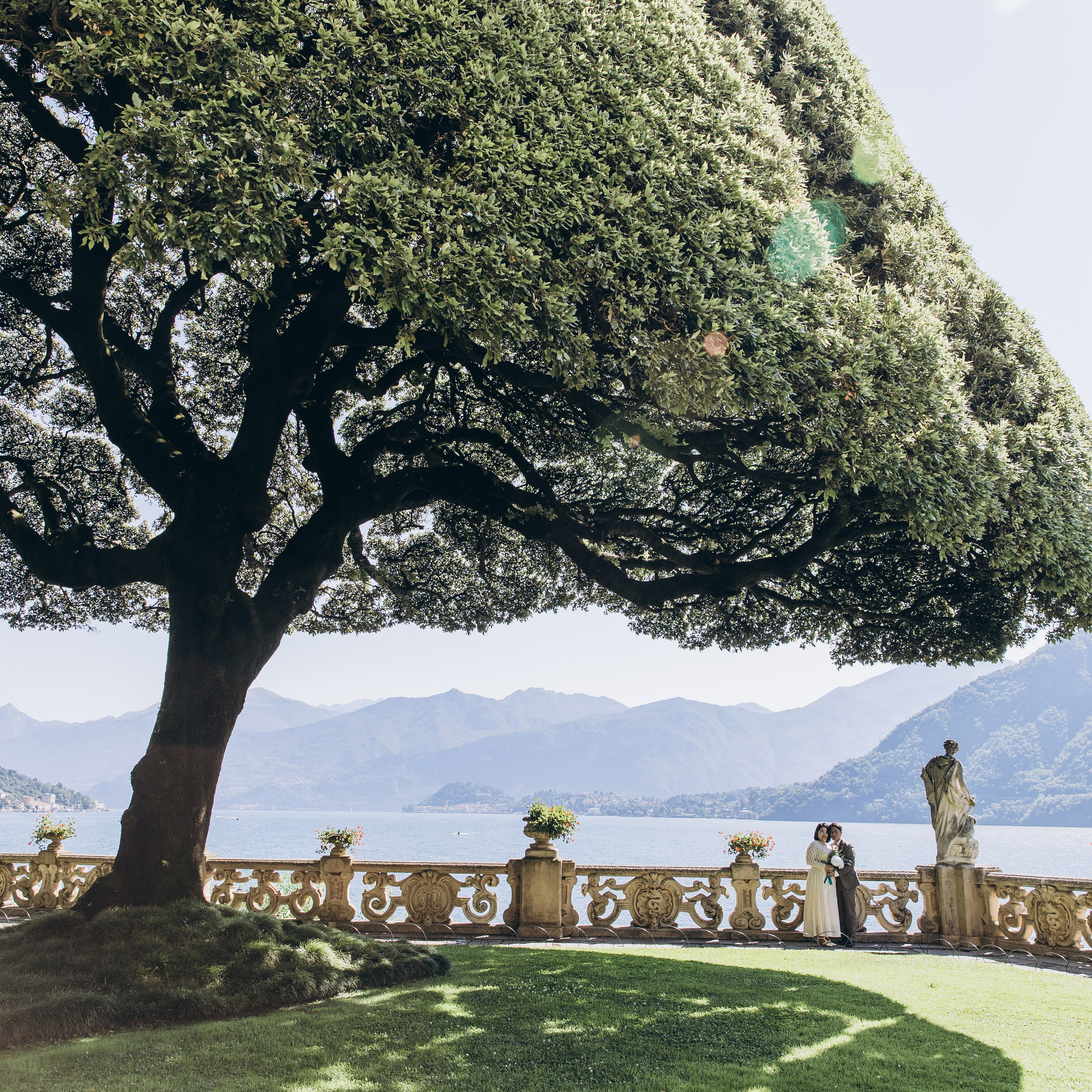 Romantic wedding photography at a Lake Como villa with a couple beneath a large garden tree