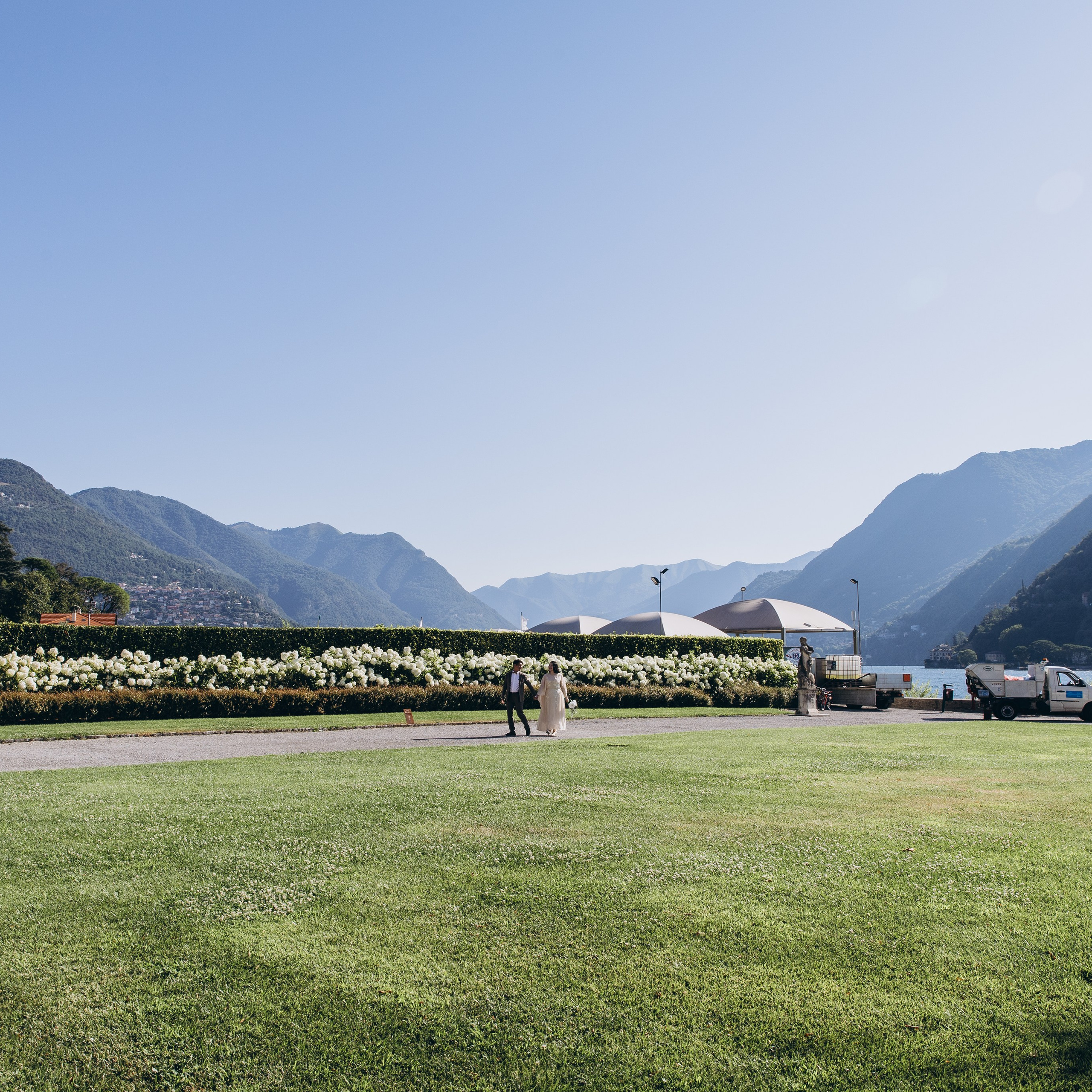 Wedding photography at Lake Como featuring a couple on a villa lawn with mountain views