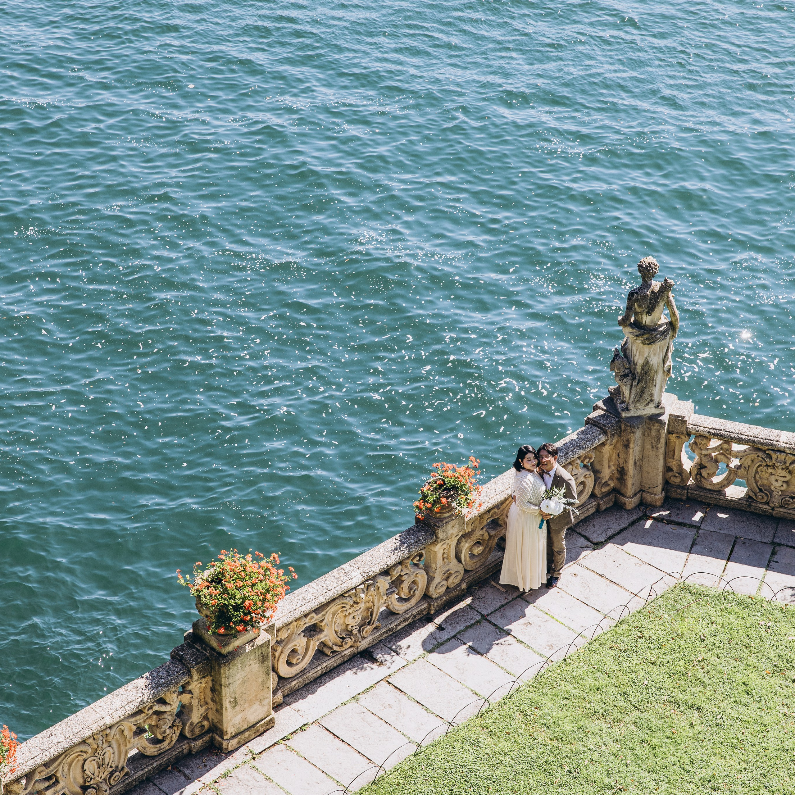 Lake Como wedding photography featuring a couple on a stone terrace above the turquoise water