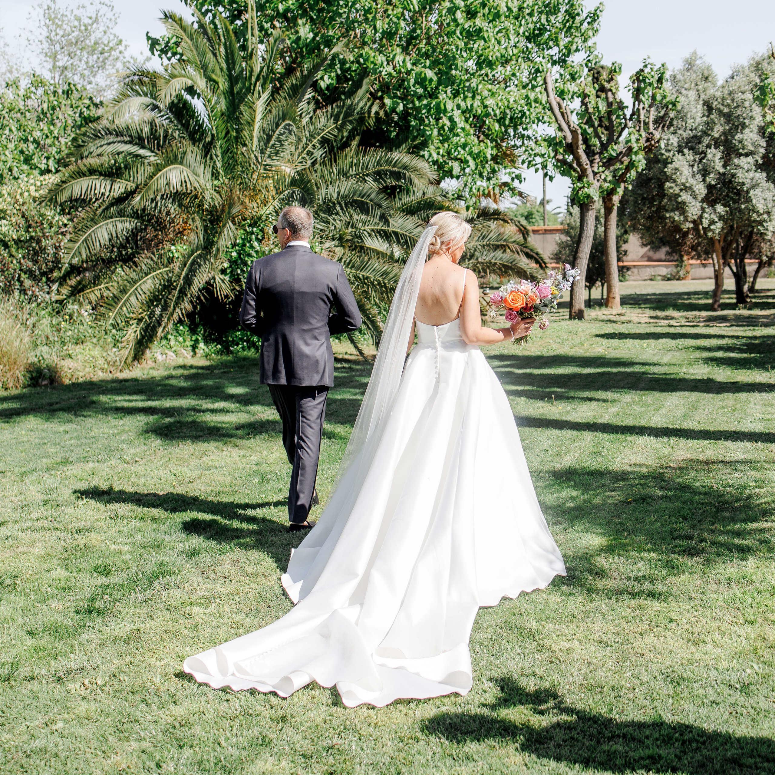 Newlyweds walk in the garden of a historical wedding venue in Spain
