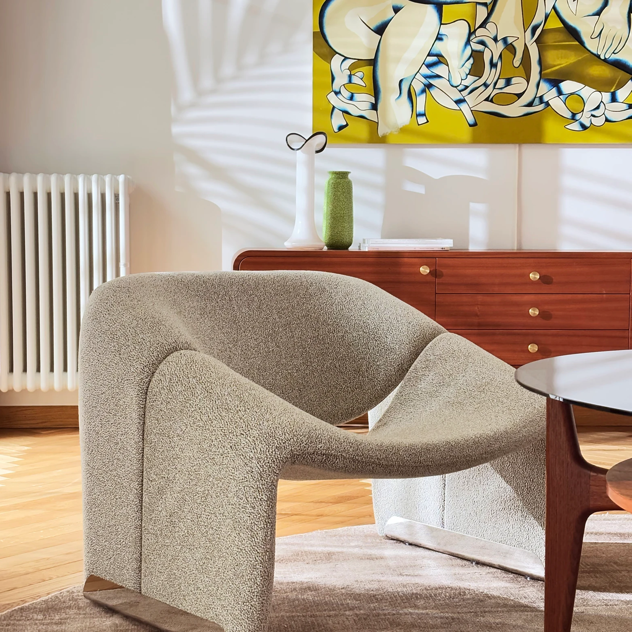 Elegancki salon z drewnianym stołem, beżową kanapą i dekoracjami w stylu retro.