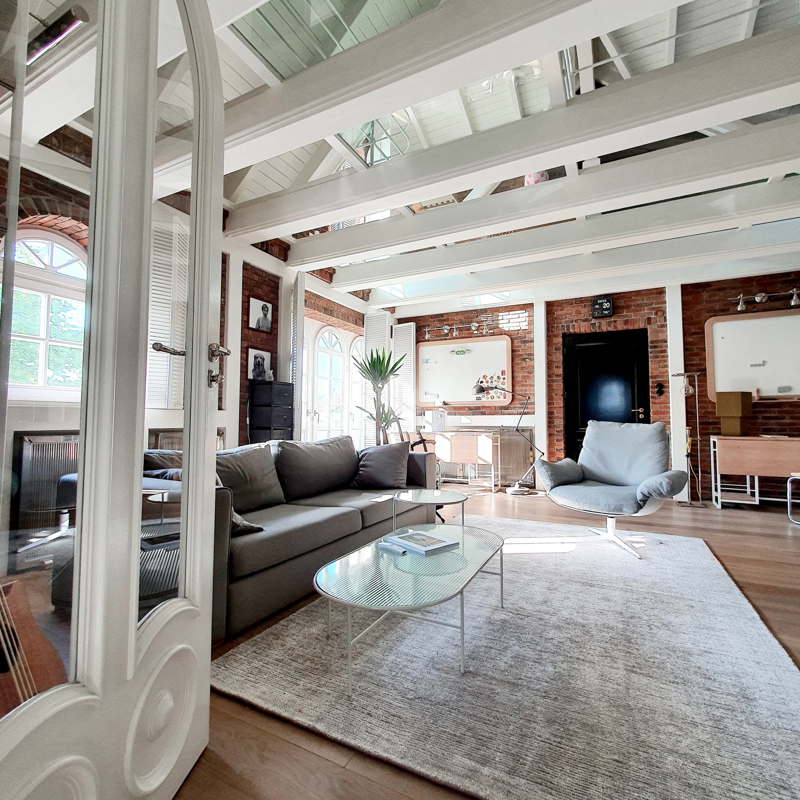 Jasny salon z dużymi oknami i drewnianą podłogą – idealne tło do zdjęć w stylu minimalistycznym.