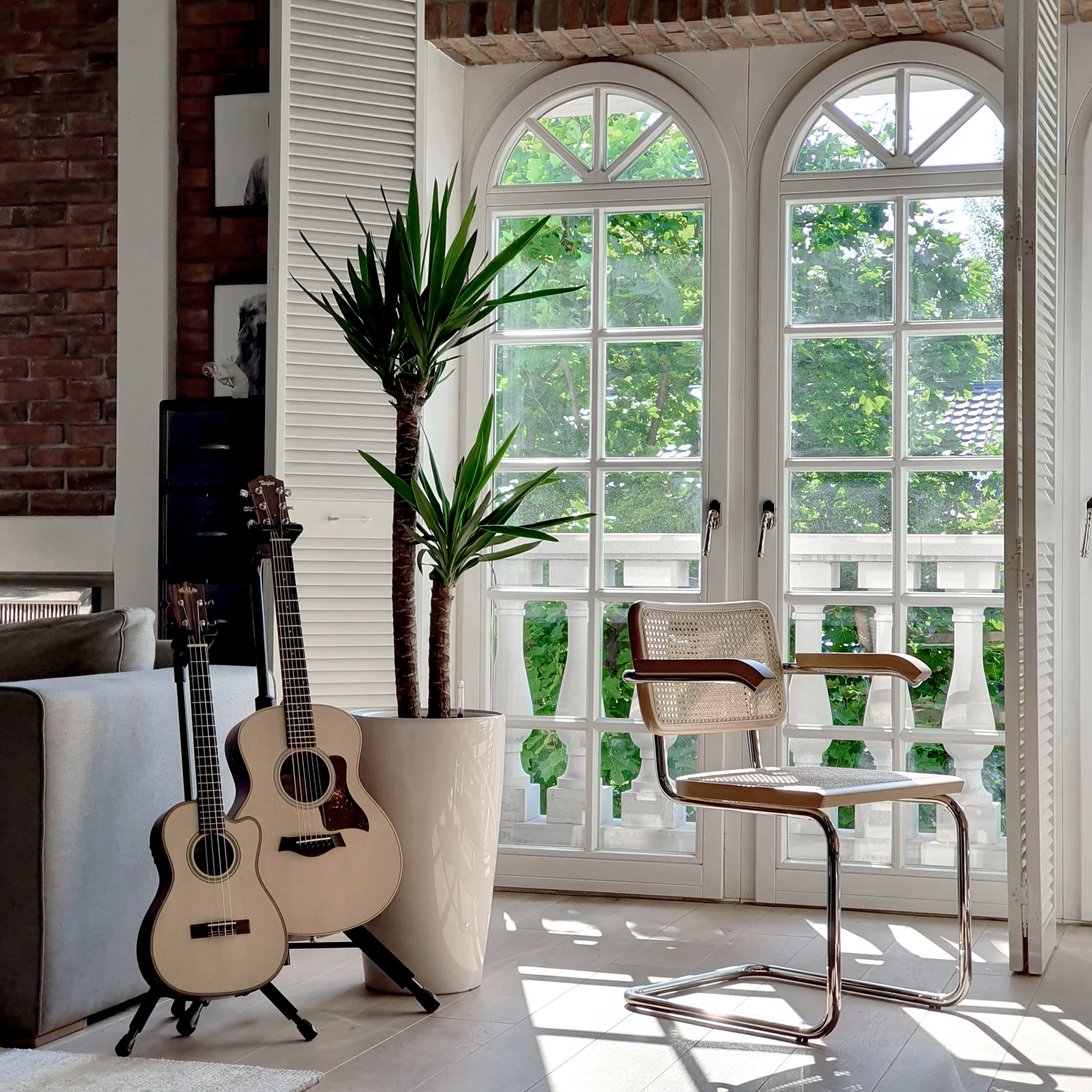 Kącik z gitarami i widokiem na ogród – artystyczna przestrzeń do sesji kreatywnych i muzycznych.