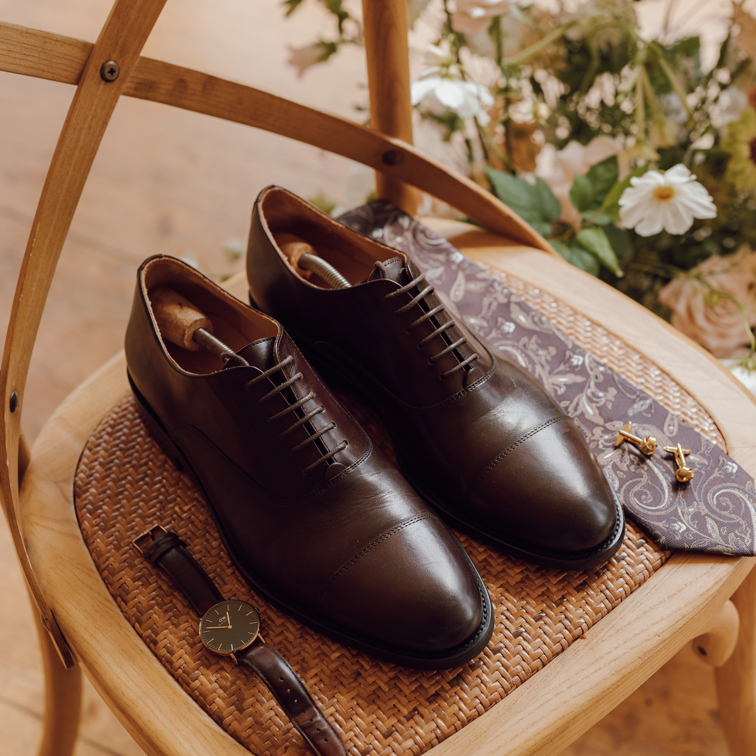 Stylowa kompozycja ślubnych akcesoriów na krześle – fotografia detali ślubnych w rustykalnym stylu.