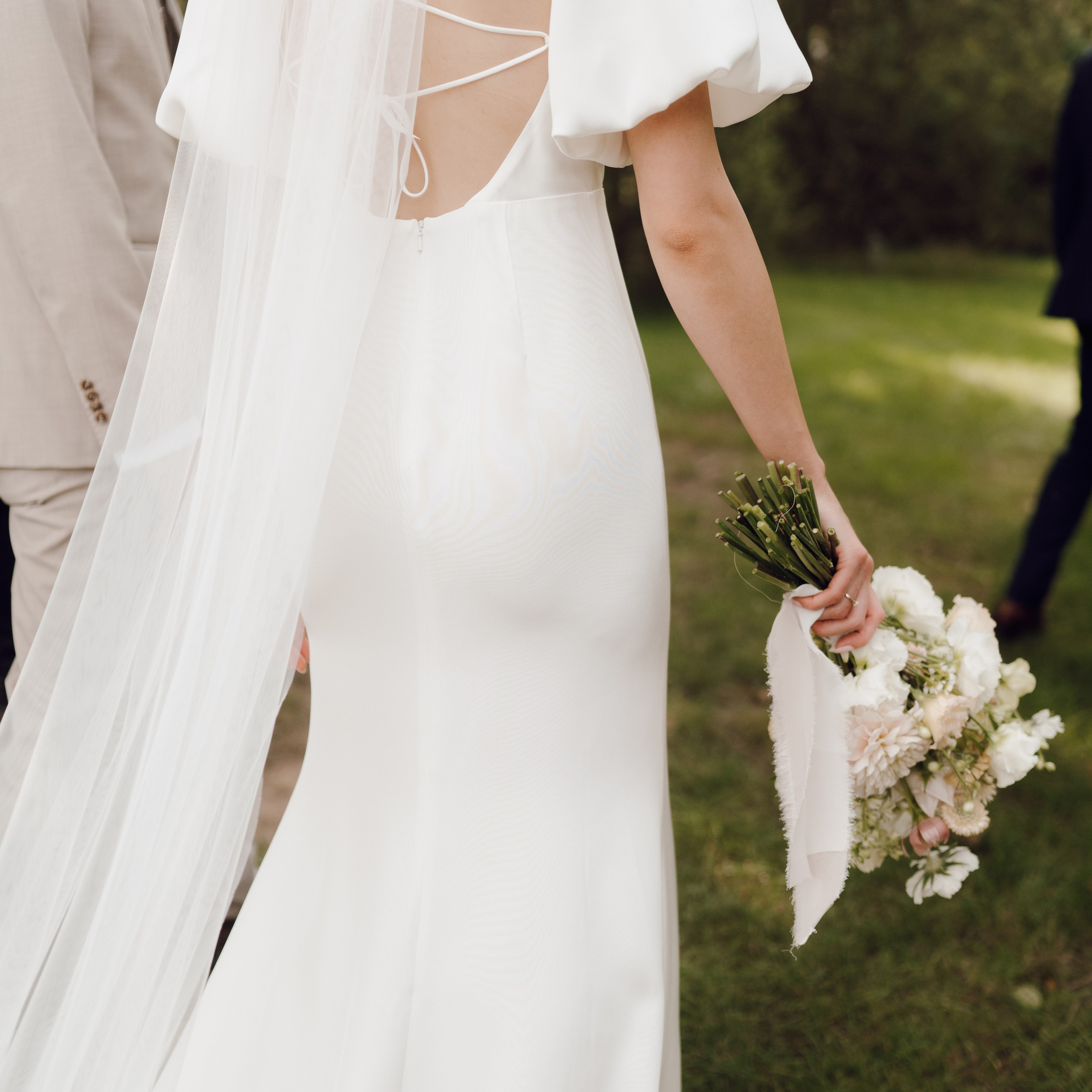 Panna młoda trzymająca bukiet, suknia z rozcięciem – rustykalna sesja ślubna, fotograf ślubny Poznań.