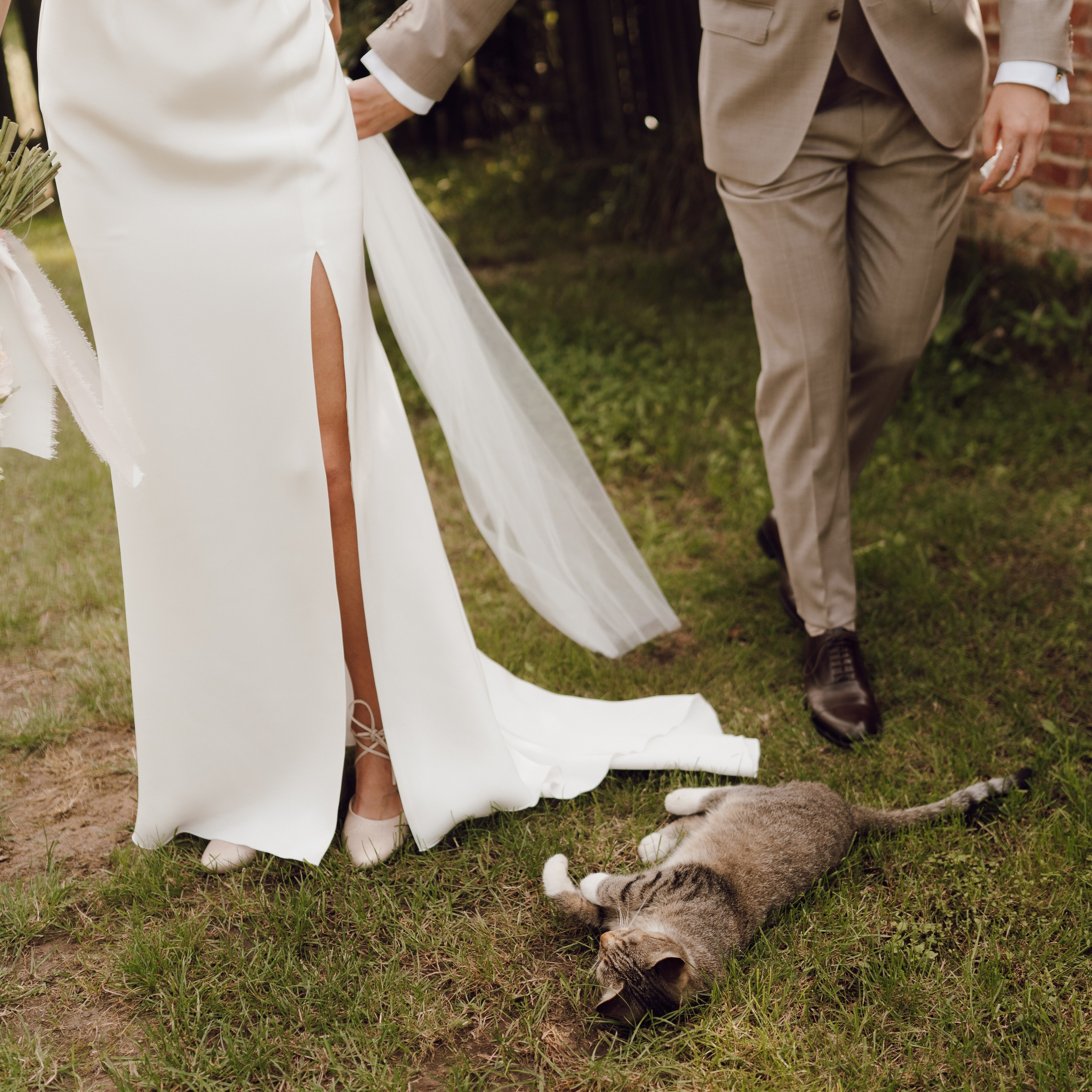 Spacer pary młodej po trawie – fotografia ślubna pełna emocji i bliskości.