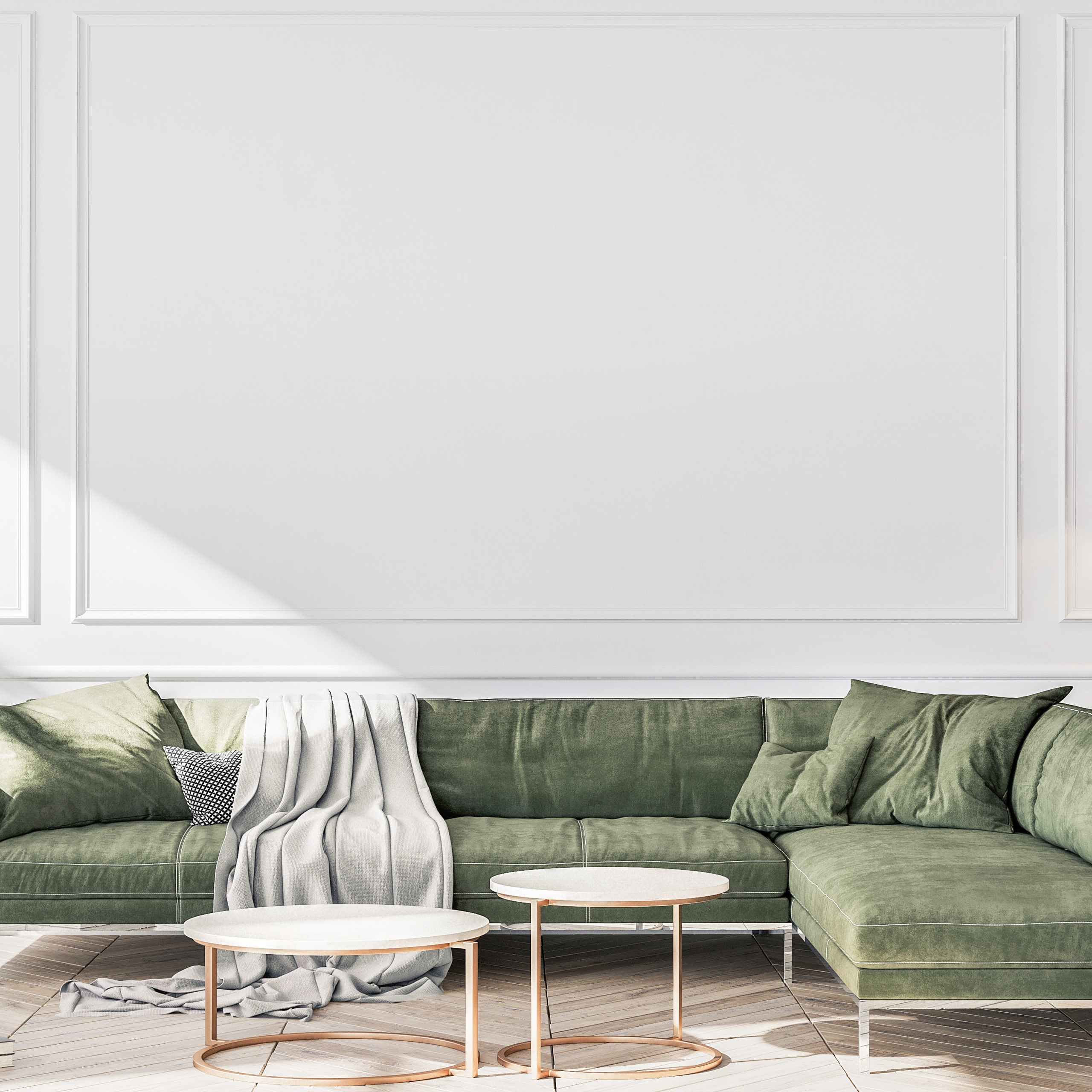 Modern living room featuring a green velvet couch, two round coffee tables, and neutral wall decor