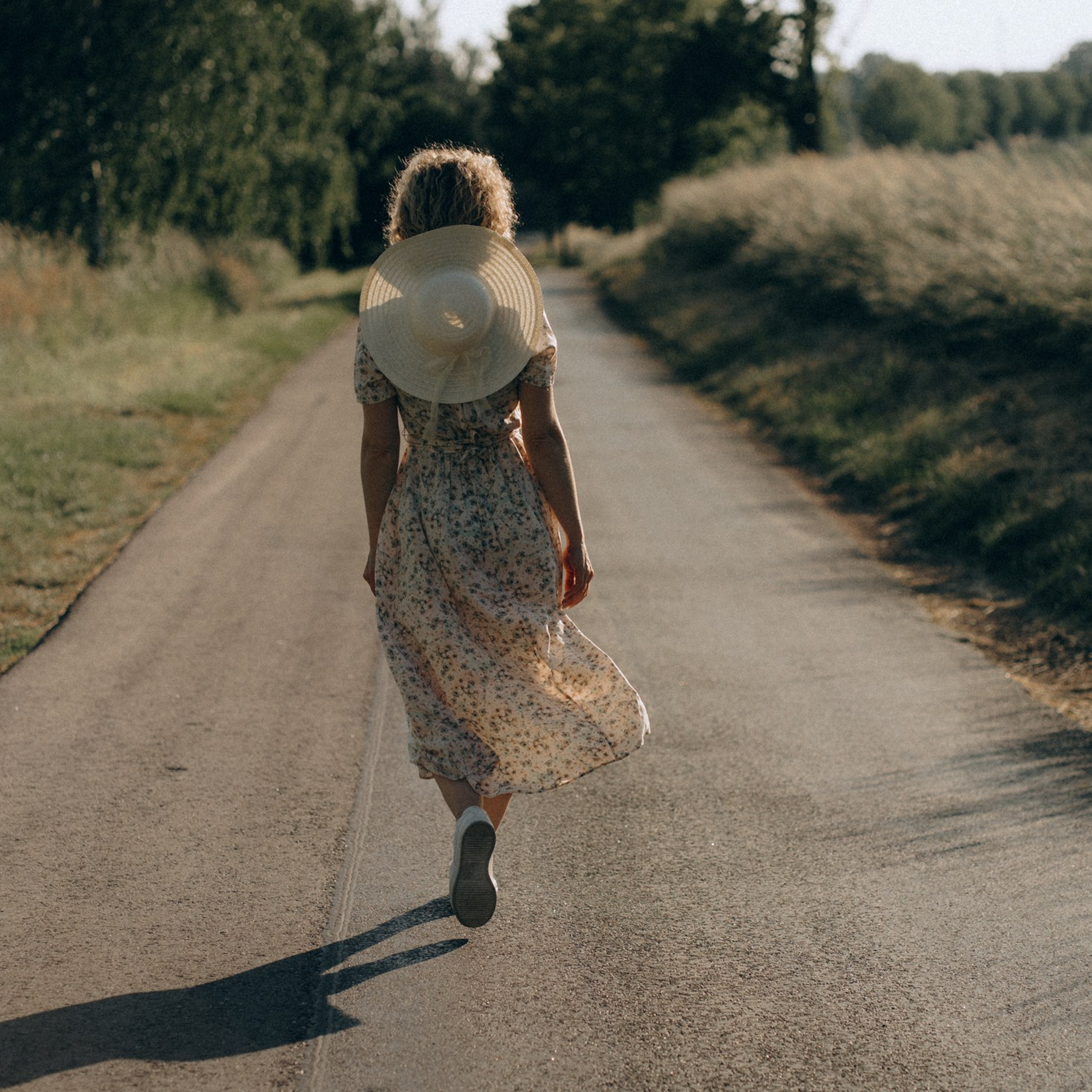 Natürliche Portraitfotos Dresden – Frau mit Hut geht auf Landstraße