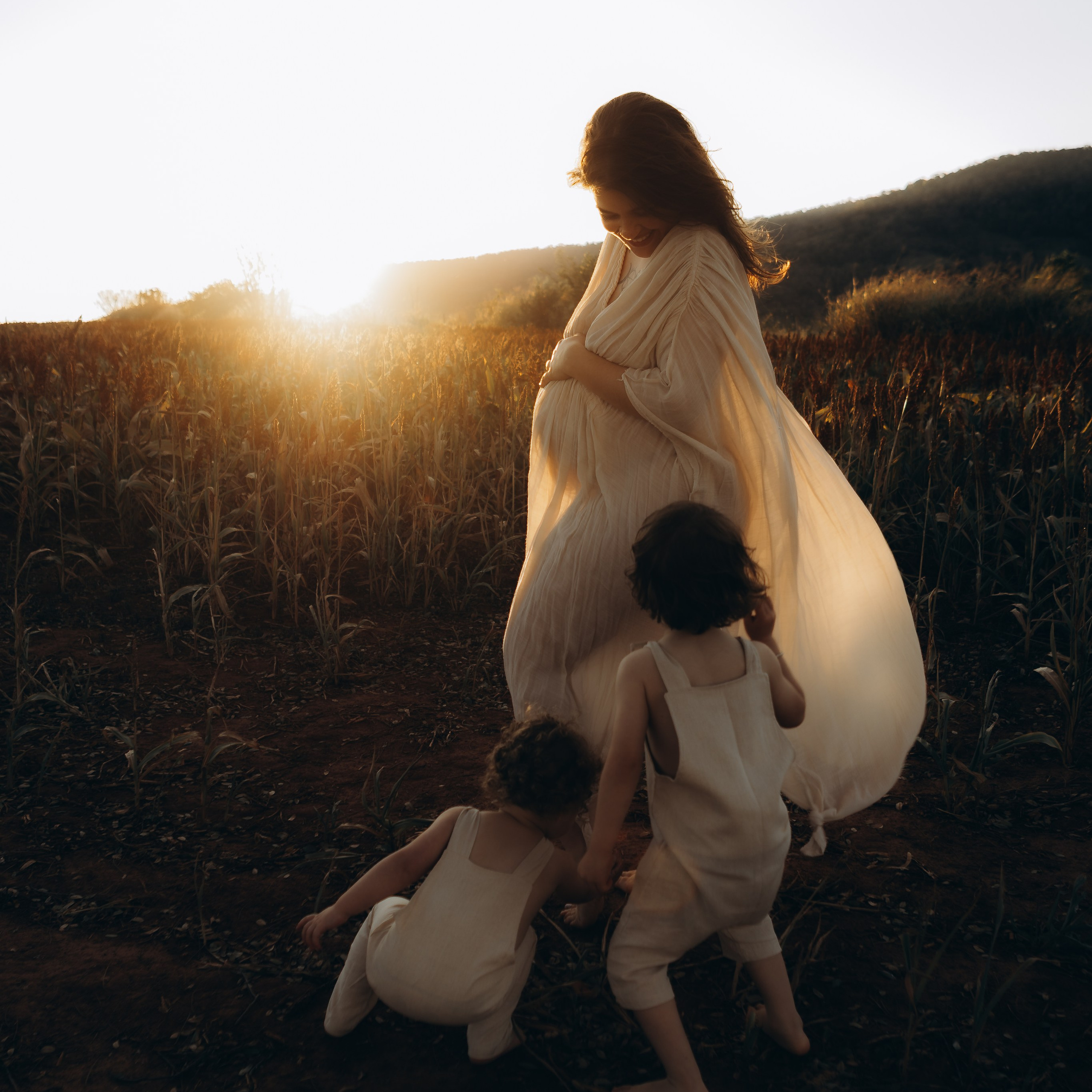 mãe observa filhos brincando em ensaio família ao ar livre em Sorocaba