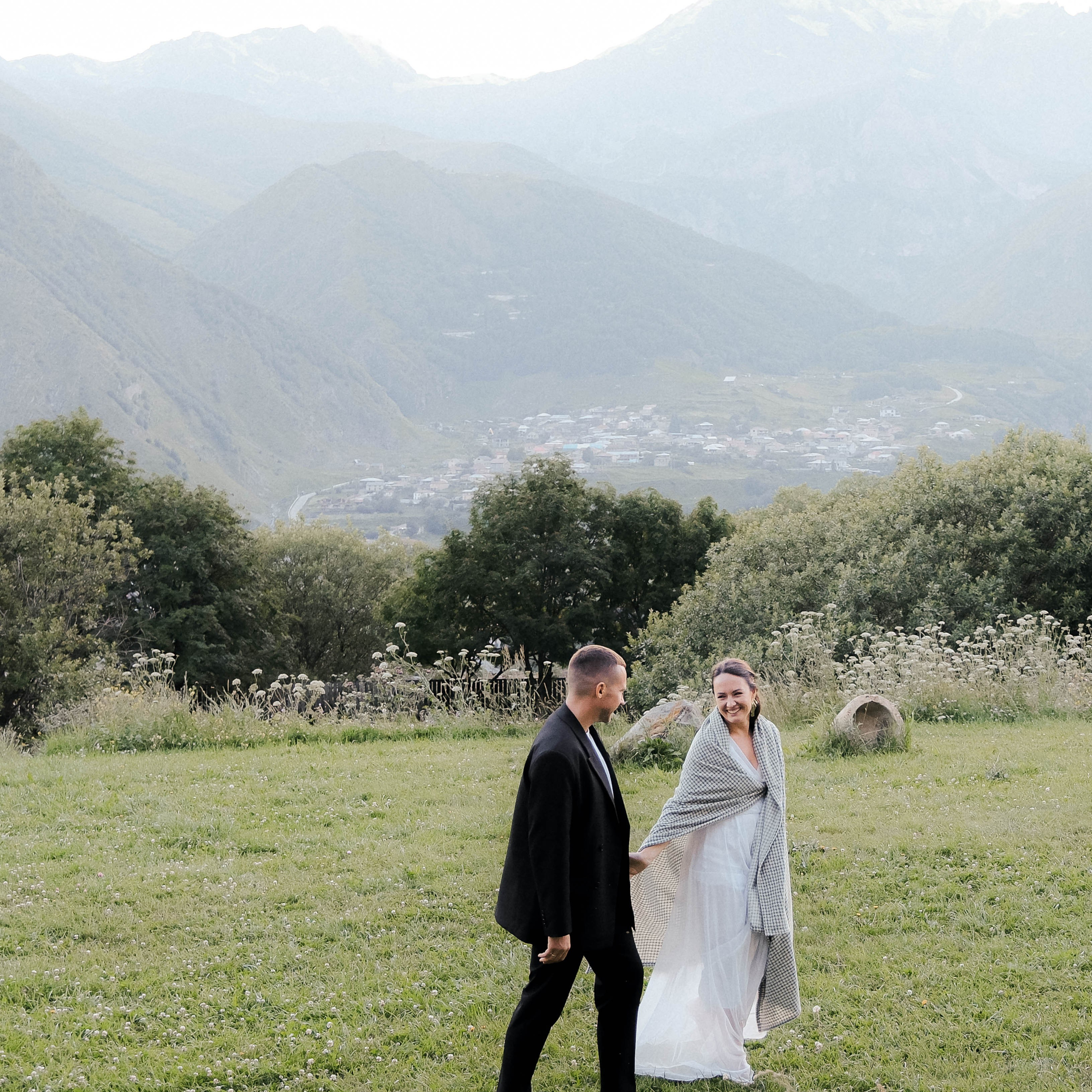 Groom and bride laughing during post-wedding photoshoot in Kazbegi