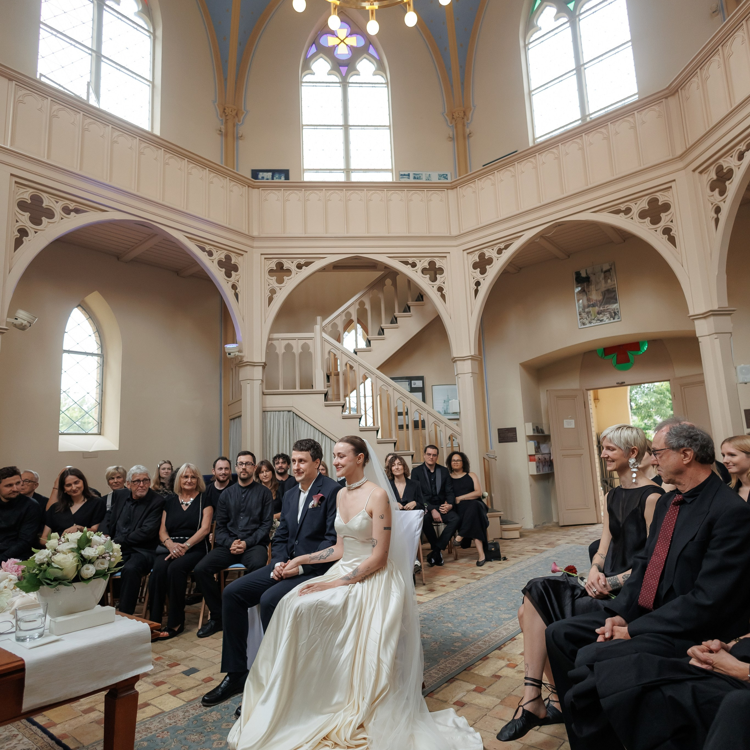Brautpaar bei der standesamtlichen Trauung in der Alten Neuendorfer Kirche in Potsdam, Blick durch den Innenraum mit den Gästen in den Bankreihen