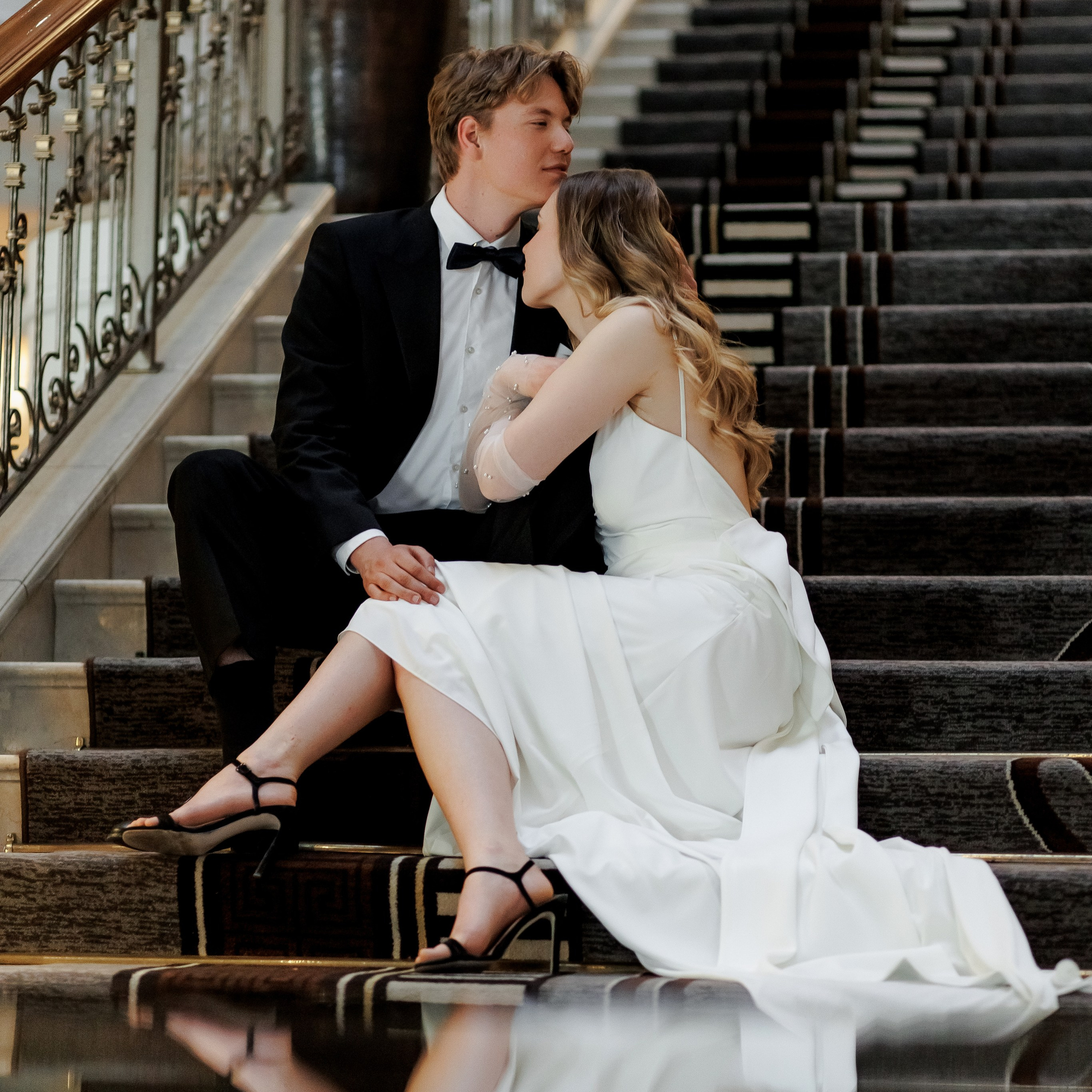 Braut sitzt lässig auf der Treppe im weißen Hochzeitskleid – Hochzeitsfotografin Berlin | Nataliia Schütze