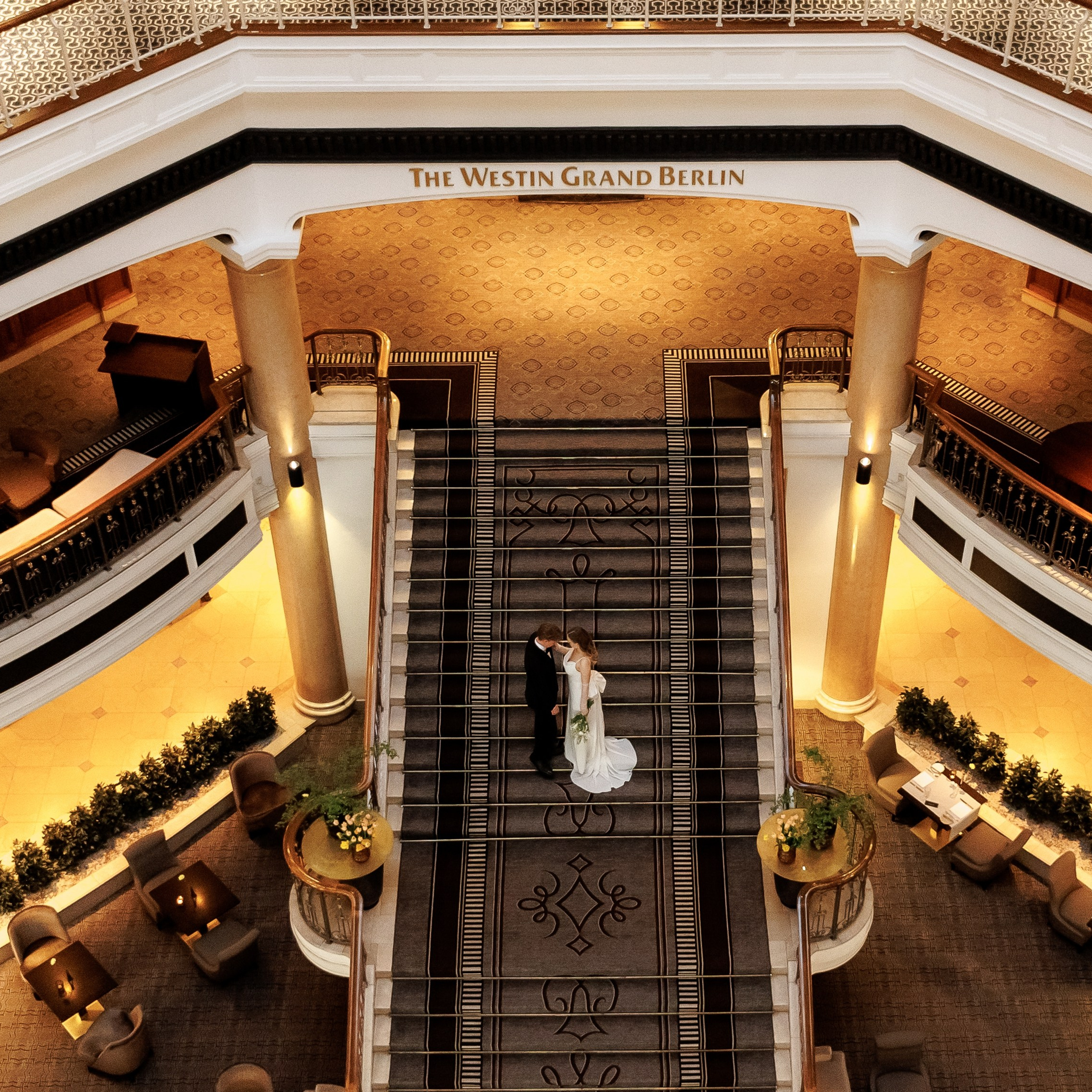 Vogelperspektive auf Hotellobby mit Braut auf der Treppe – Hochzeitsfotograf Berlin | Nataliia Schütze