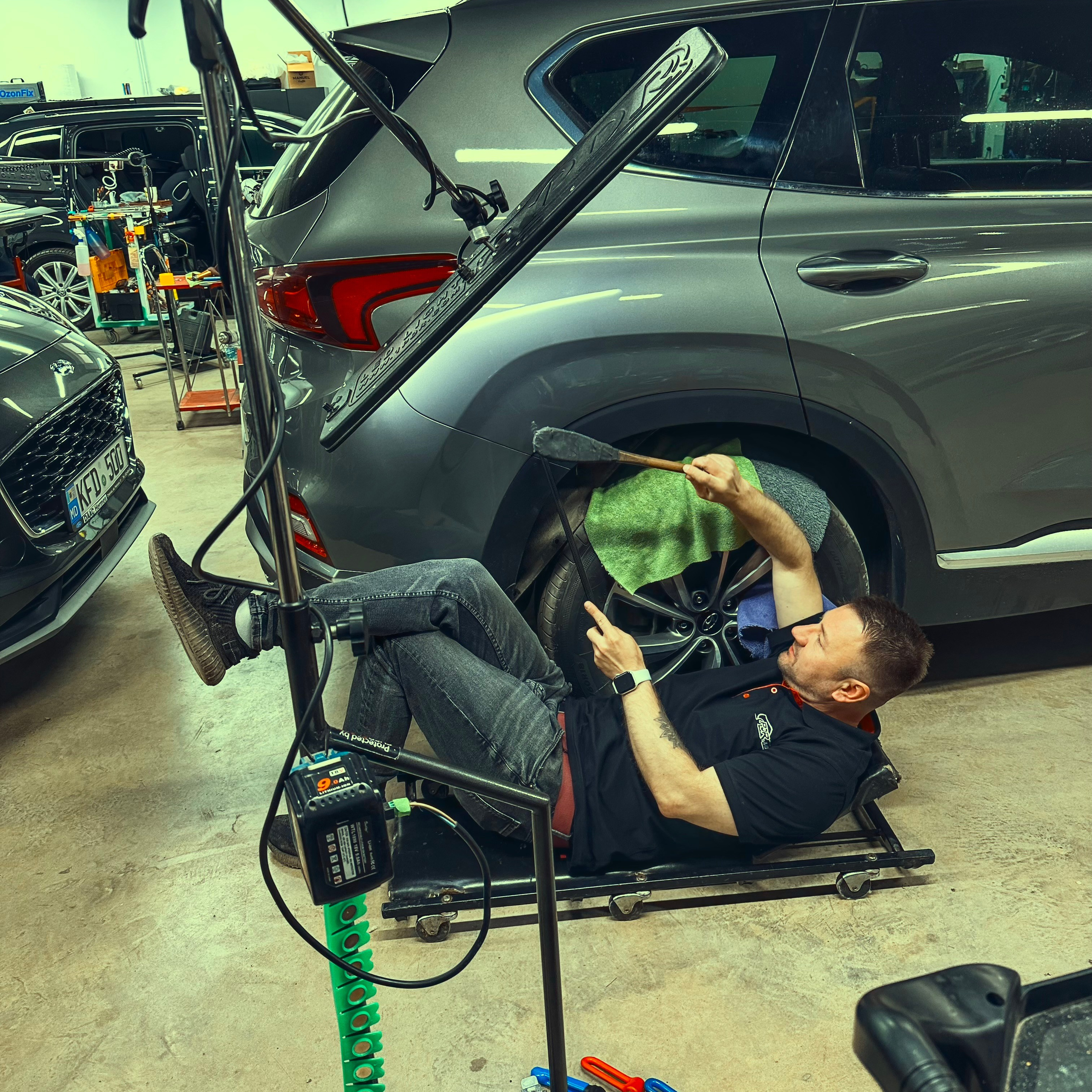 Автомобиль премиум класса, находящийся в процессе полировки у профессионального мастера"