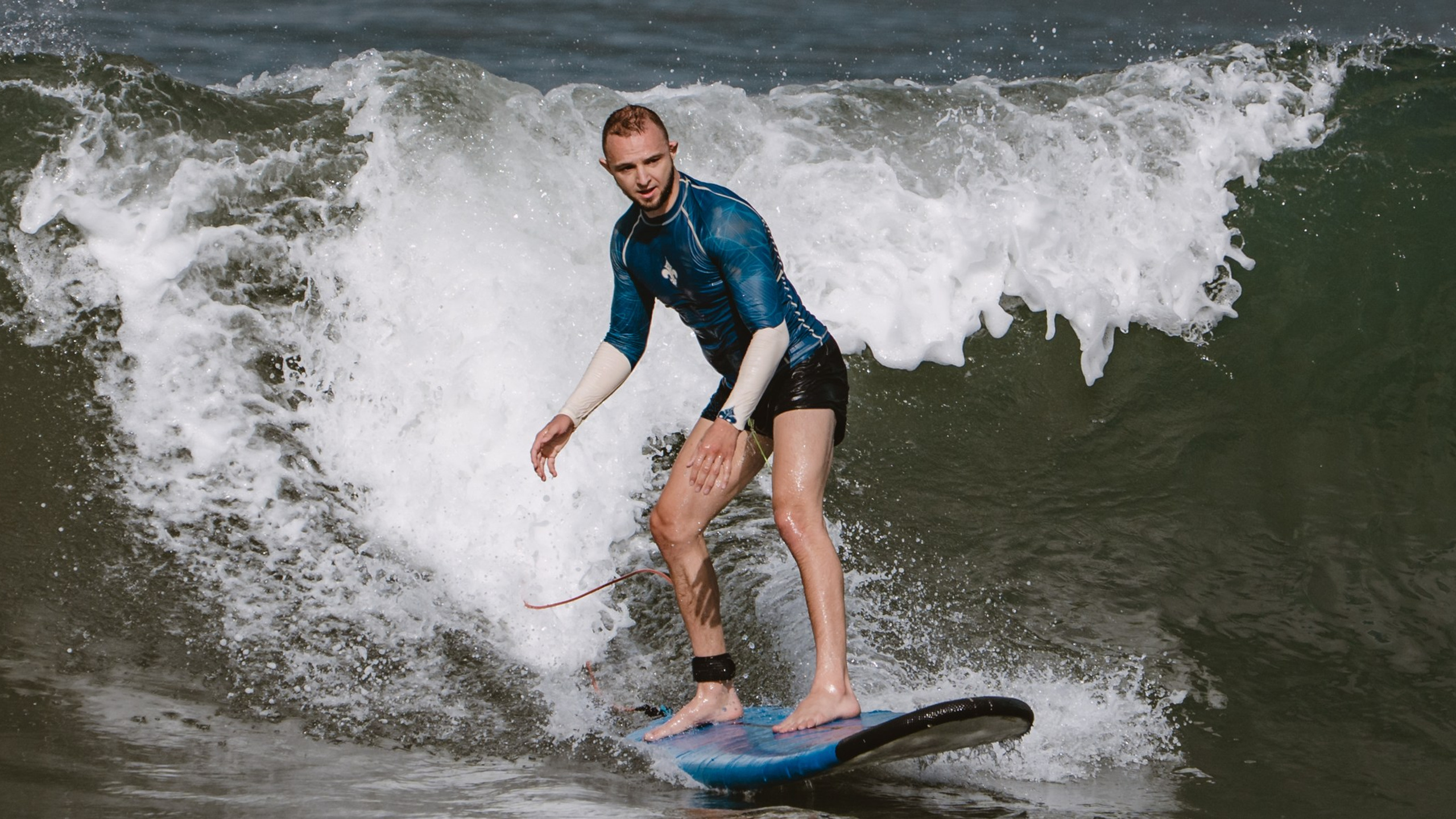 Mixed martial artists having fun surfing at&nbsp;the ocean in&nbsp;between training sessions