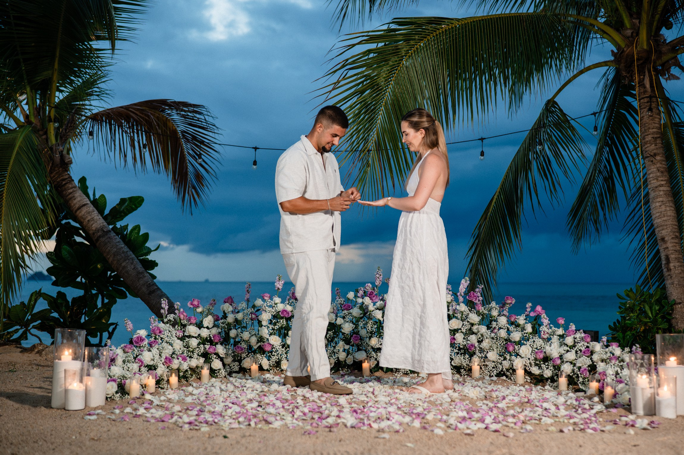 Elegant “Marry Me” beach proposal setup in Koh Samui with rose petals and tropical decor.