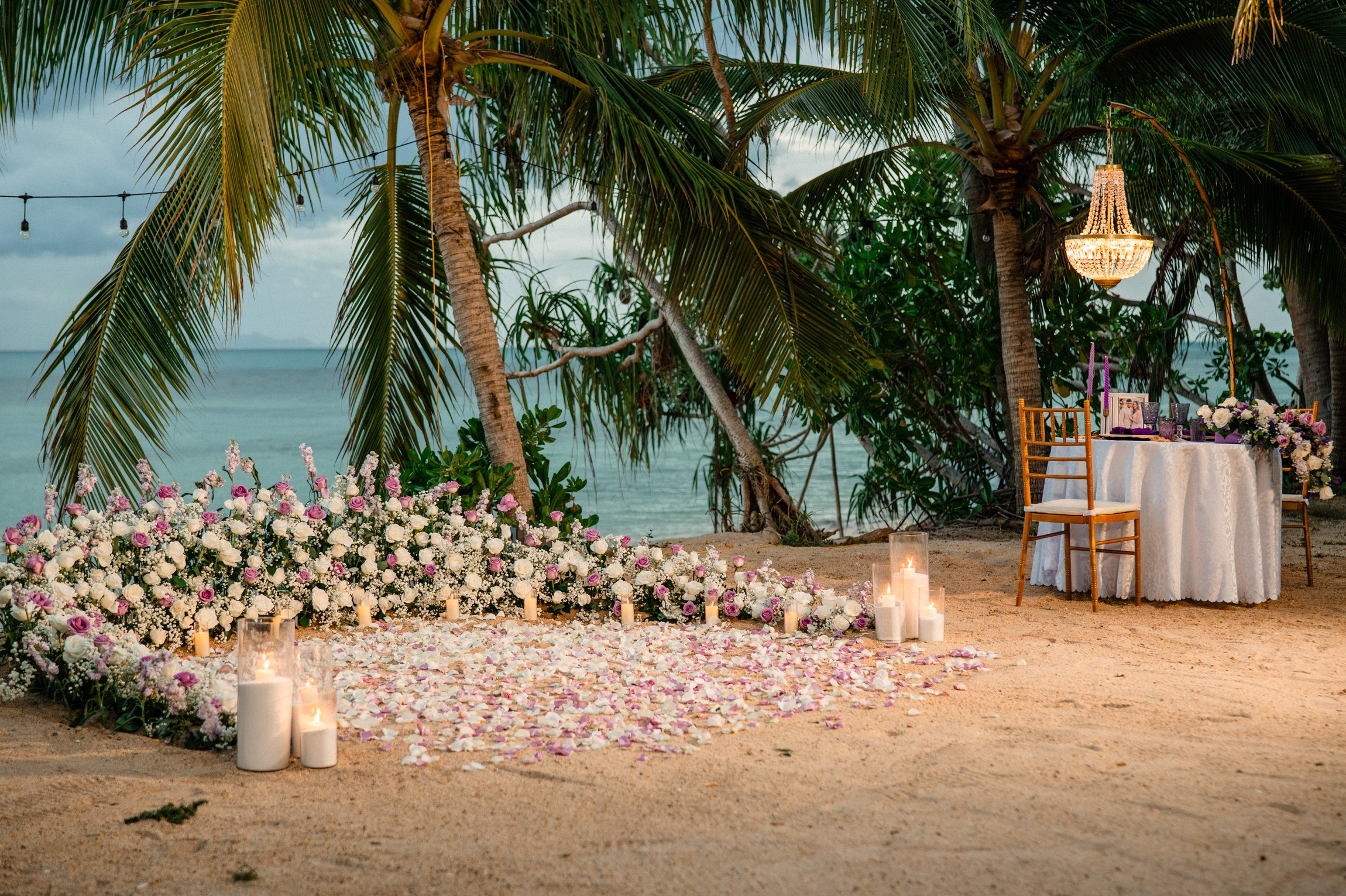 Luxury marriage proposal on a private beach in Koh Samui with flower decorations and romantic lighting.