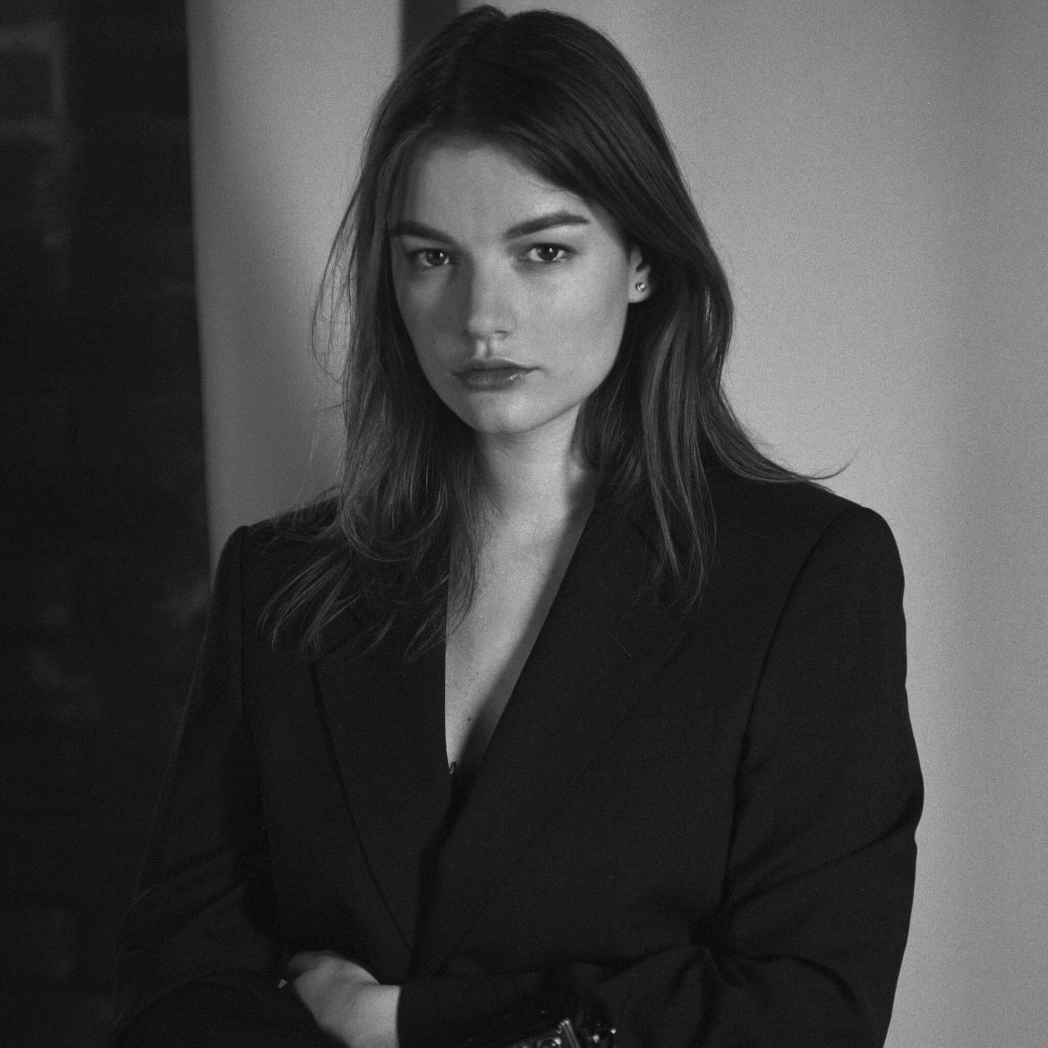 Black and white studio portrait of Lake Como photographer Inna Zaytseva in a tailored black blazer