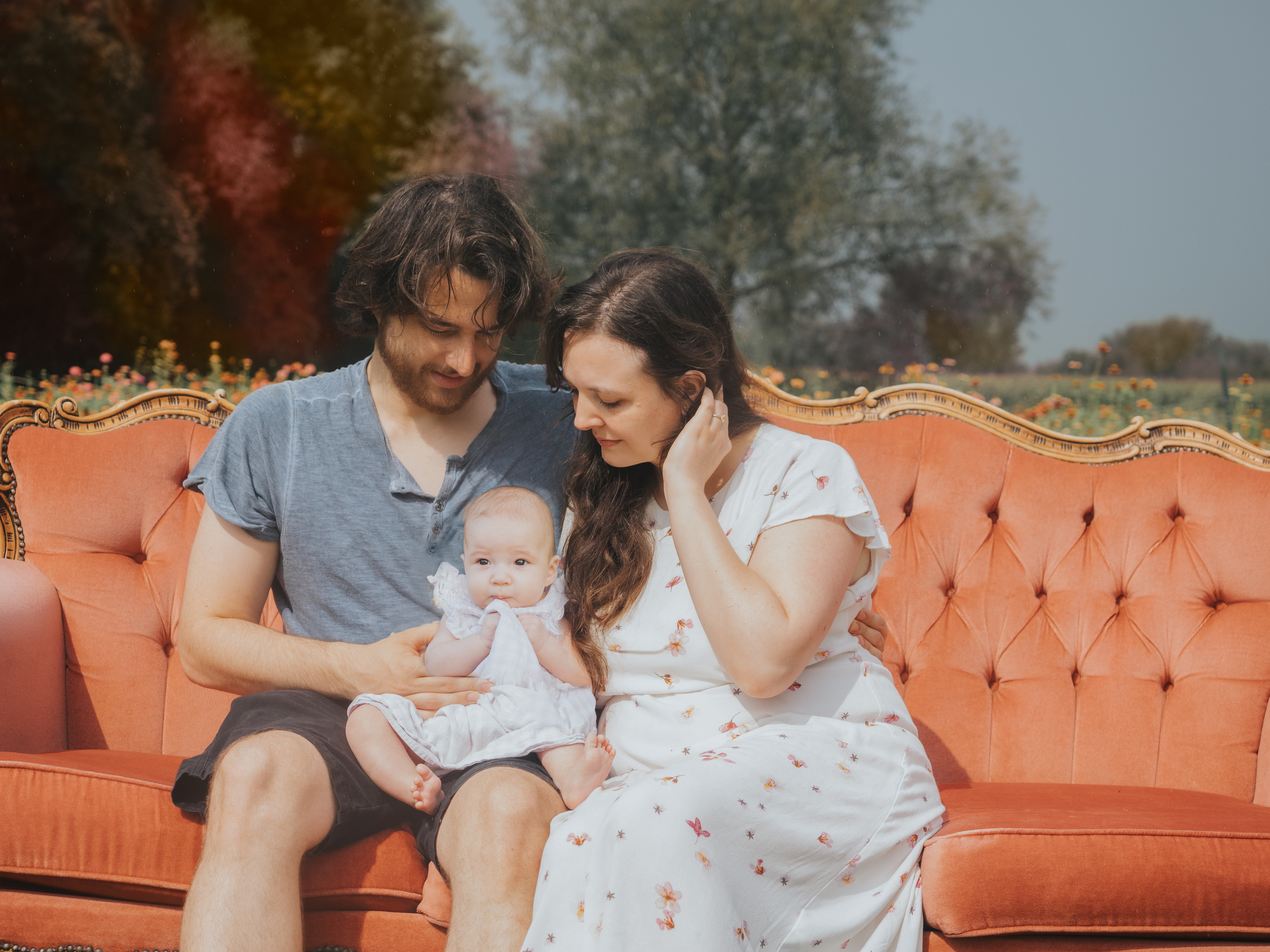 Photo of family of three sitting on vintage couch for a family photoshoot.