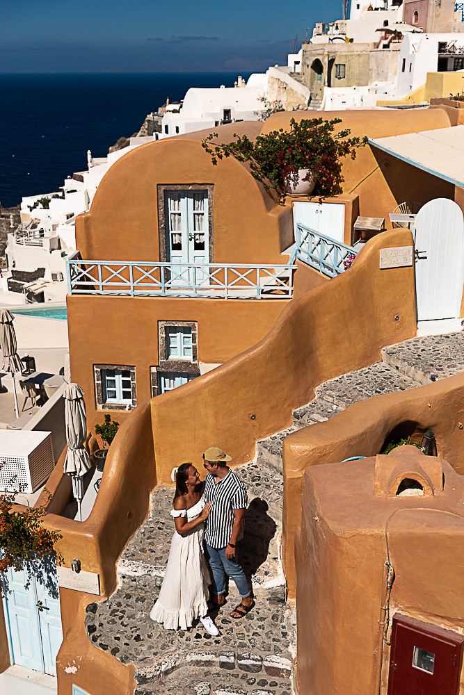 A couple walks the streets of Santorini with a photographer in Santorini