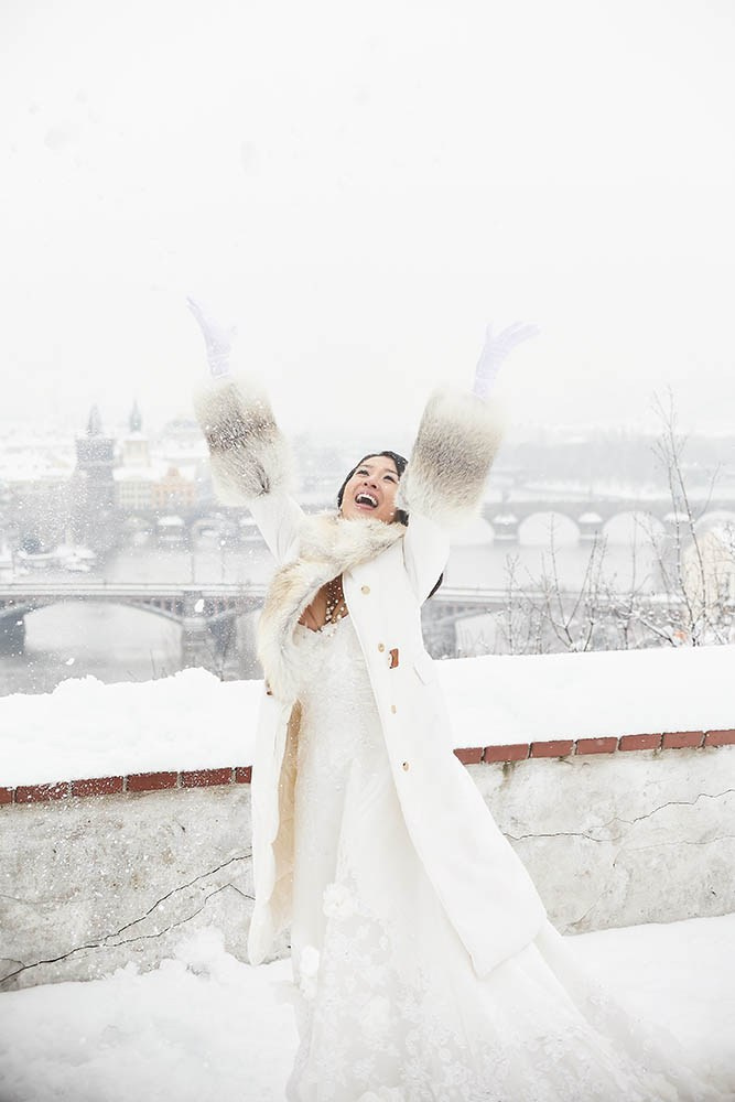 Helen, wearing fine jewelry and a sable fur coat, catches snow above Prague during her pre-wedding.