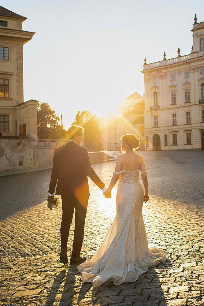 Ina and Vladimir are walking towards the sunshine near the Archbishops Palace at Prague Castle