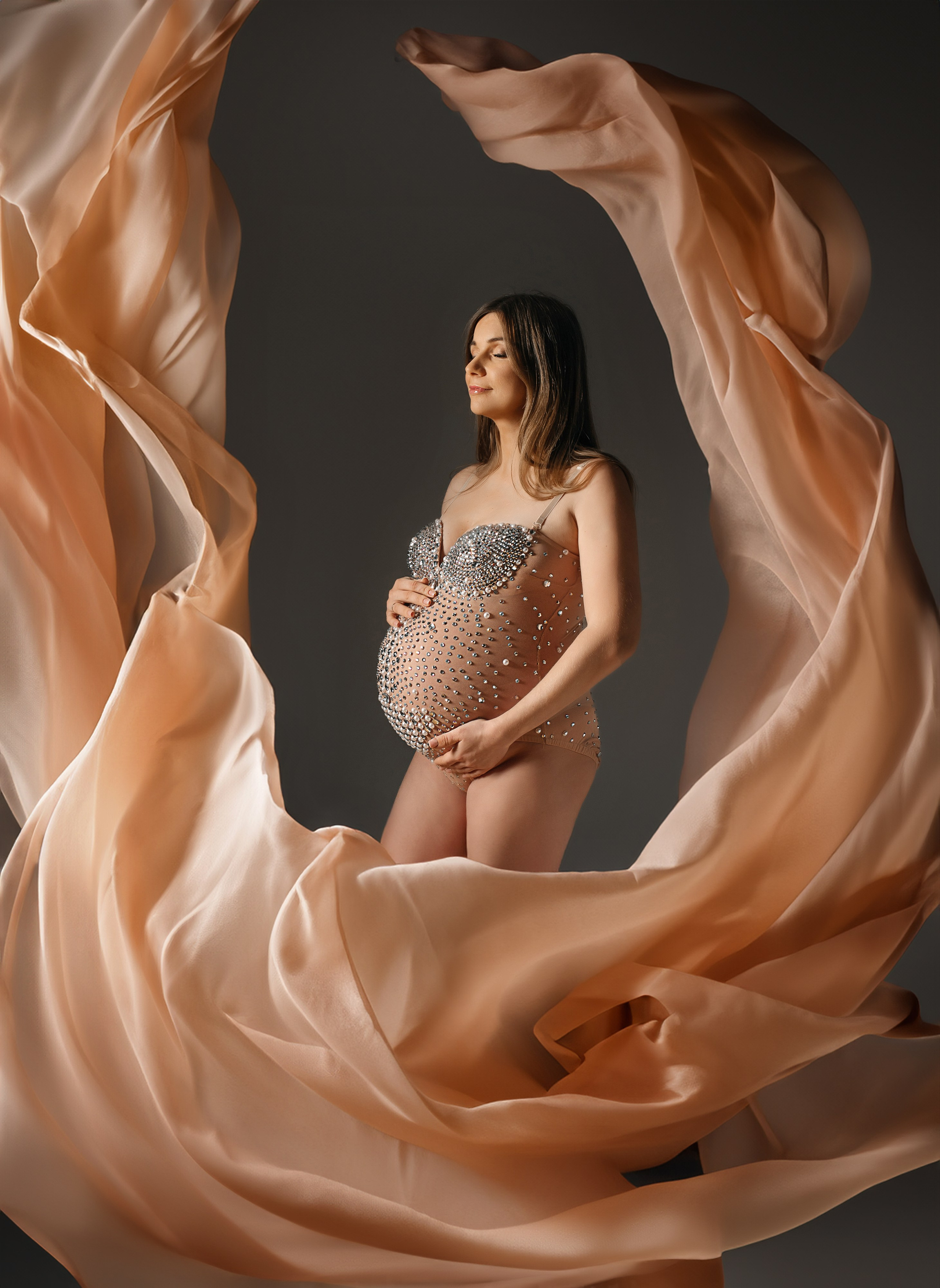 Schwangere Frau in einem fließenden Kleid – elegante und emotionale Schwangerschaftsfotografie von Anna Saribekyan.