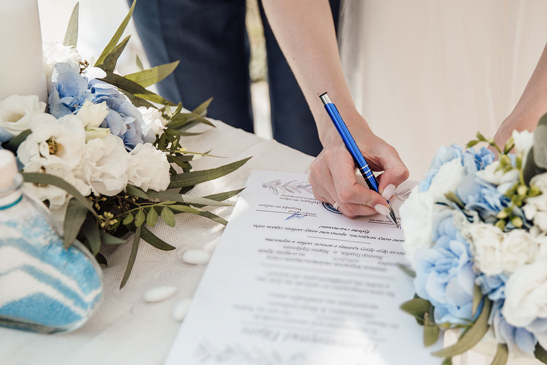 Невеста подписывает свидетельство на свадебной церемонии на Крите. Фотограф, свадьба в Греции.