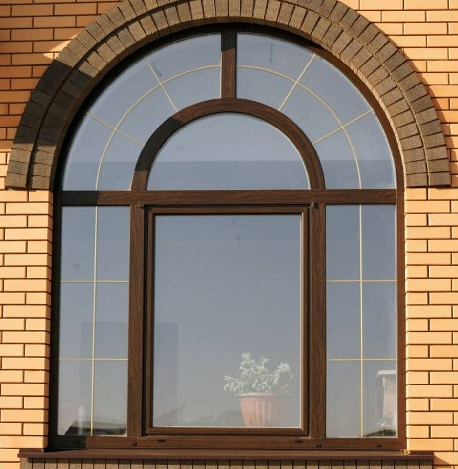 Большое пластиковое арочное окно в ламинации цвета Золотой Дуб с декоративными элементами - шпроссами.