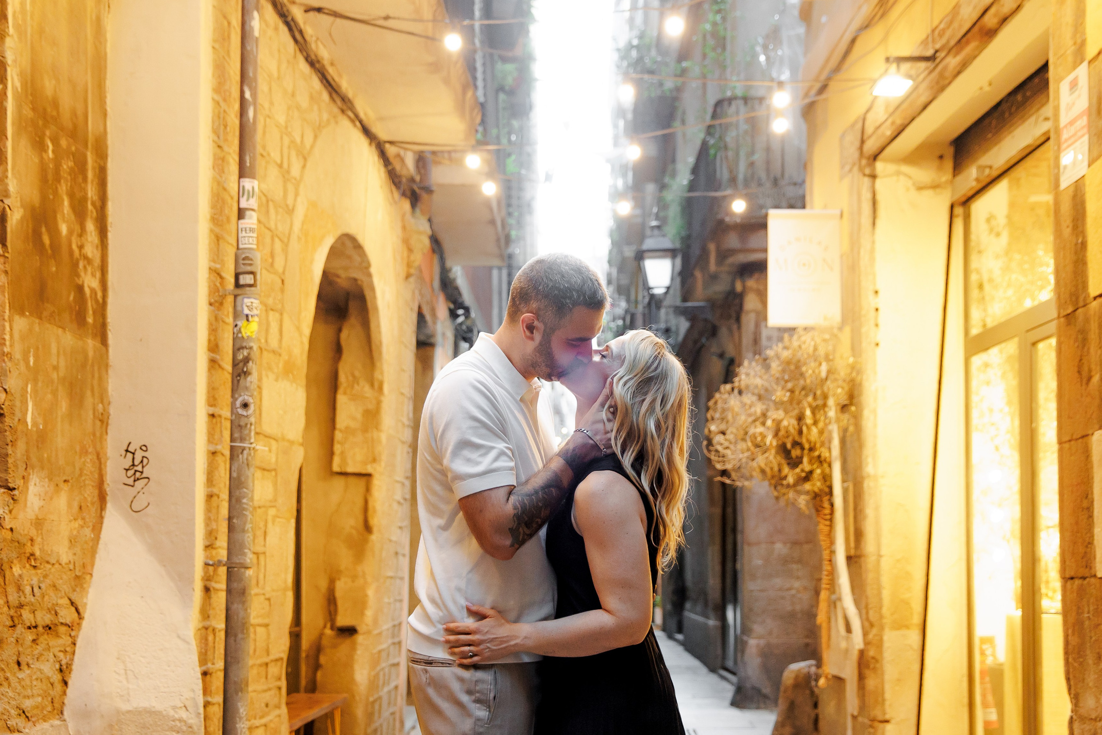 A couple sharing a passionate kiss during their romantic walk in the historical area of Barcelona