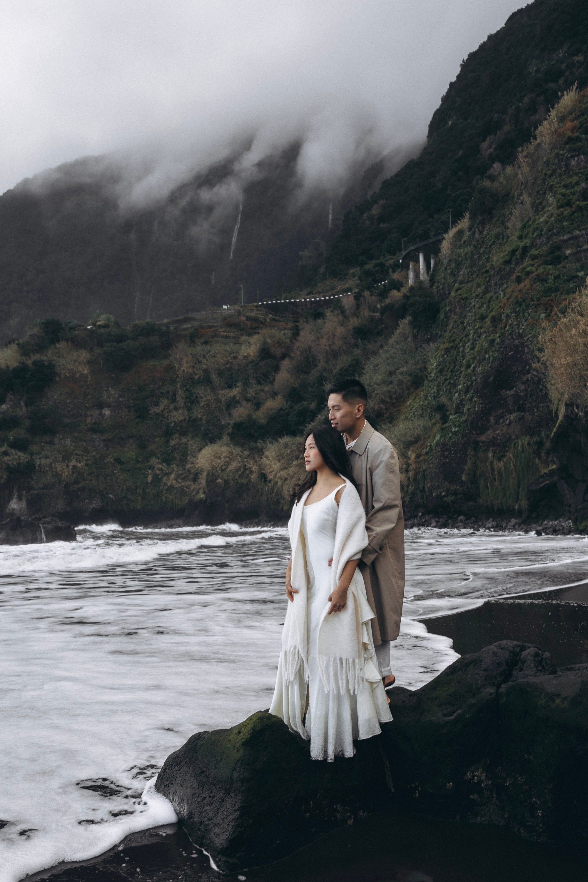cinematic couple walking on Seixal black sand beach Madeira reflection ocean photo