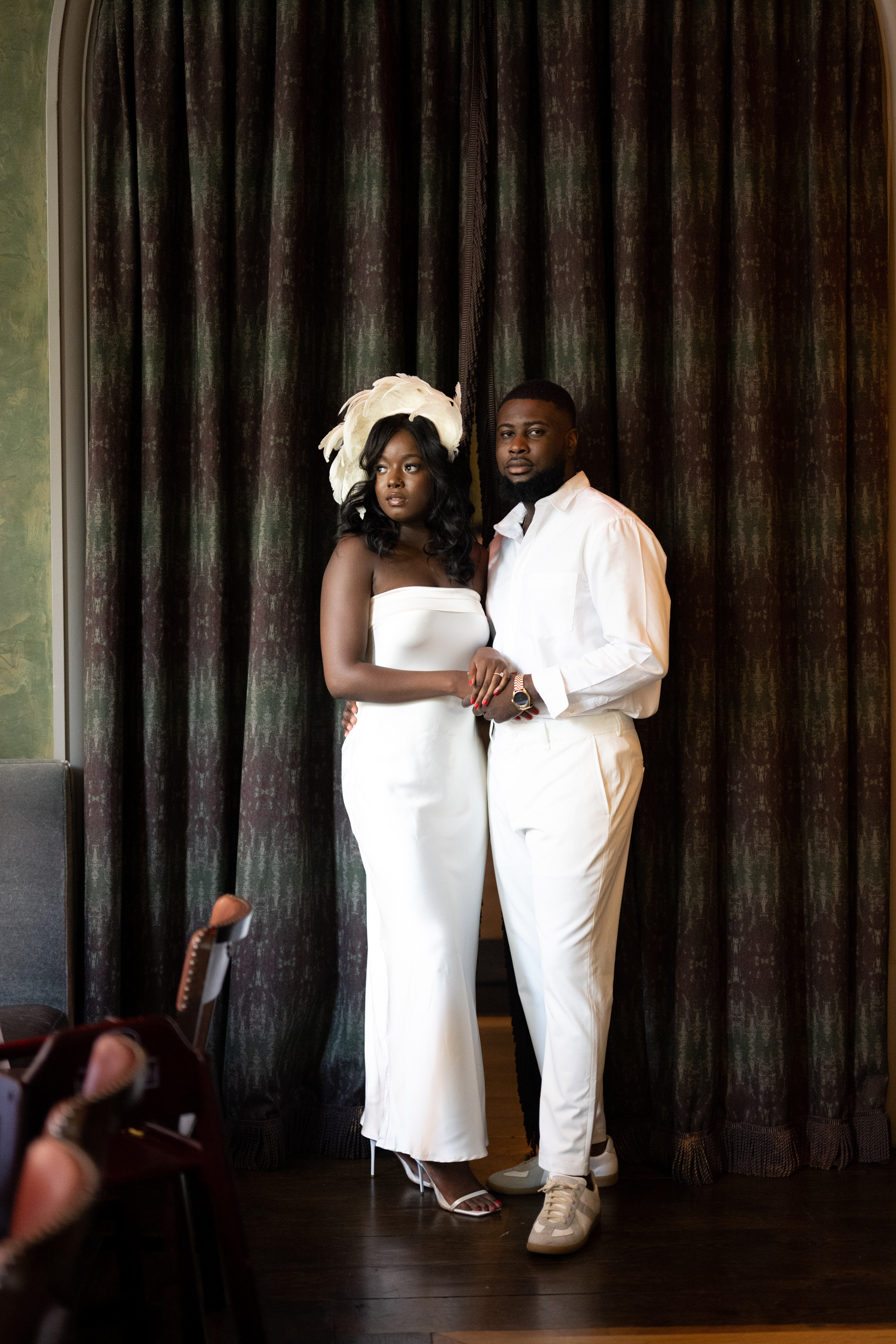 a man and woman standing in front of a curtain
