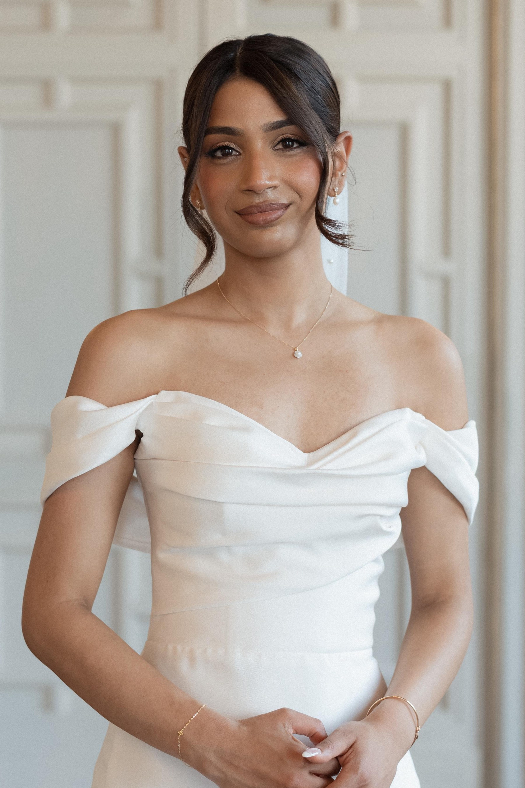 Bride with natural bridal makeup holding white roses, refined and timeless wedding beauty