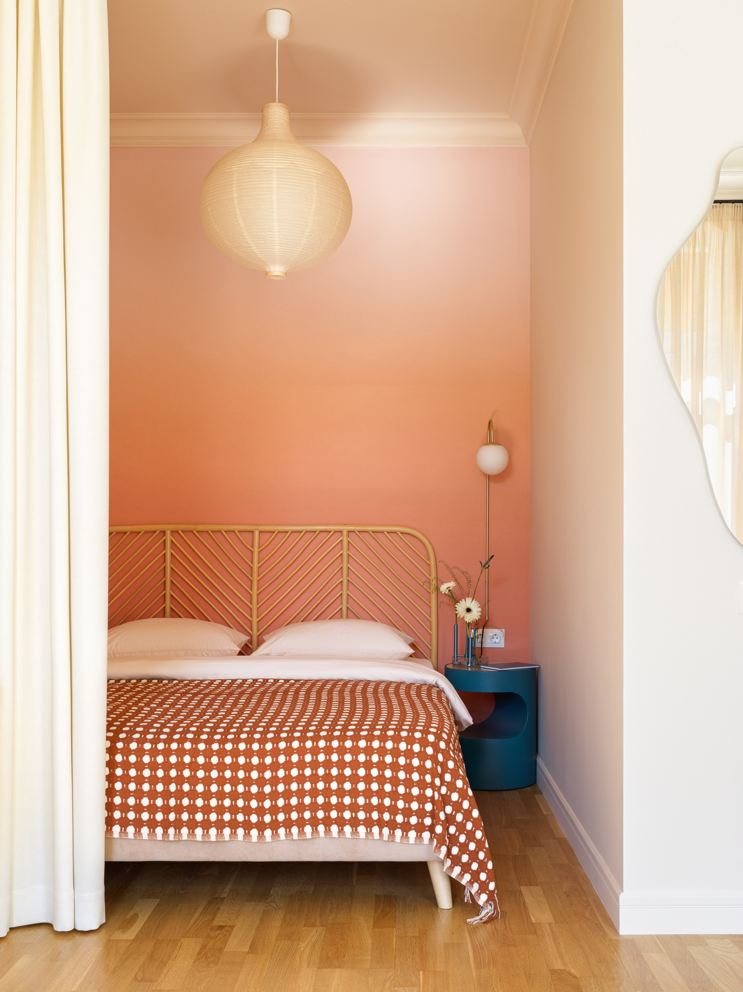 Спальня, отделенная шторой, с акцентной градиентной стеной.