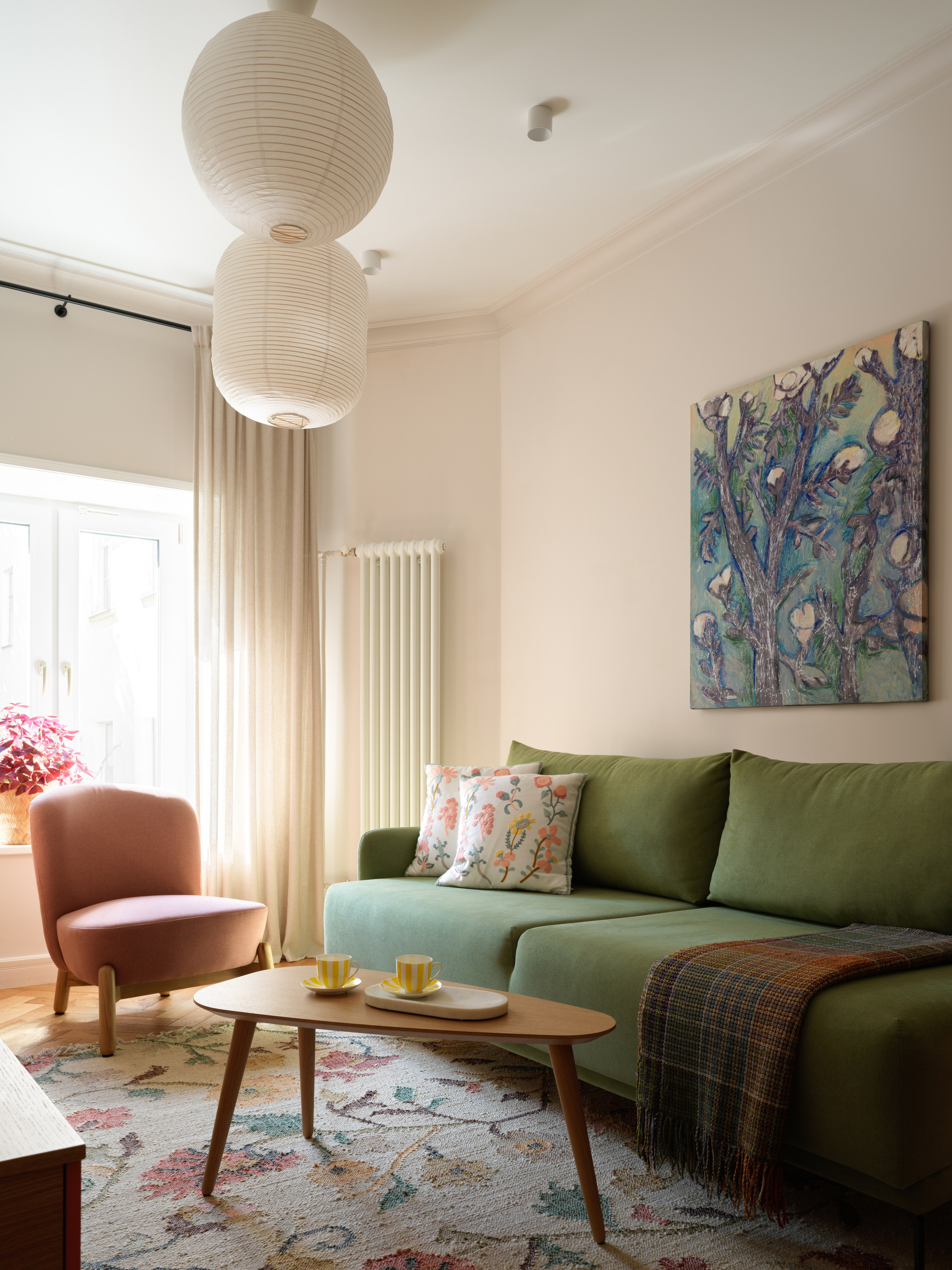 Акцентный зелёный диван в центре гостиной.