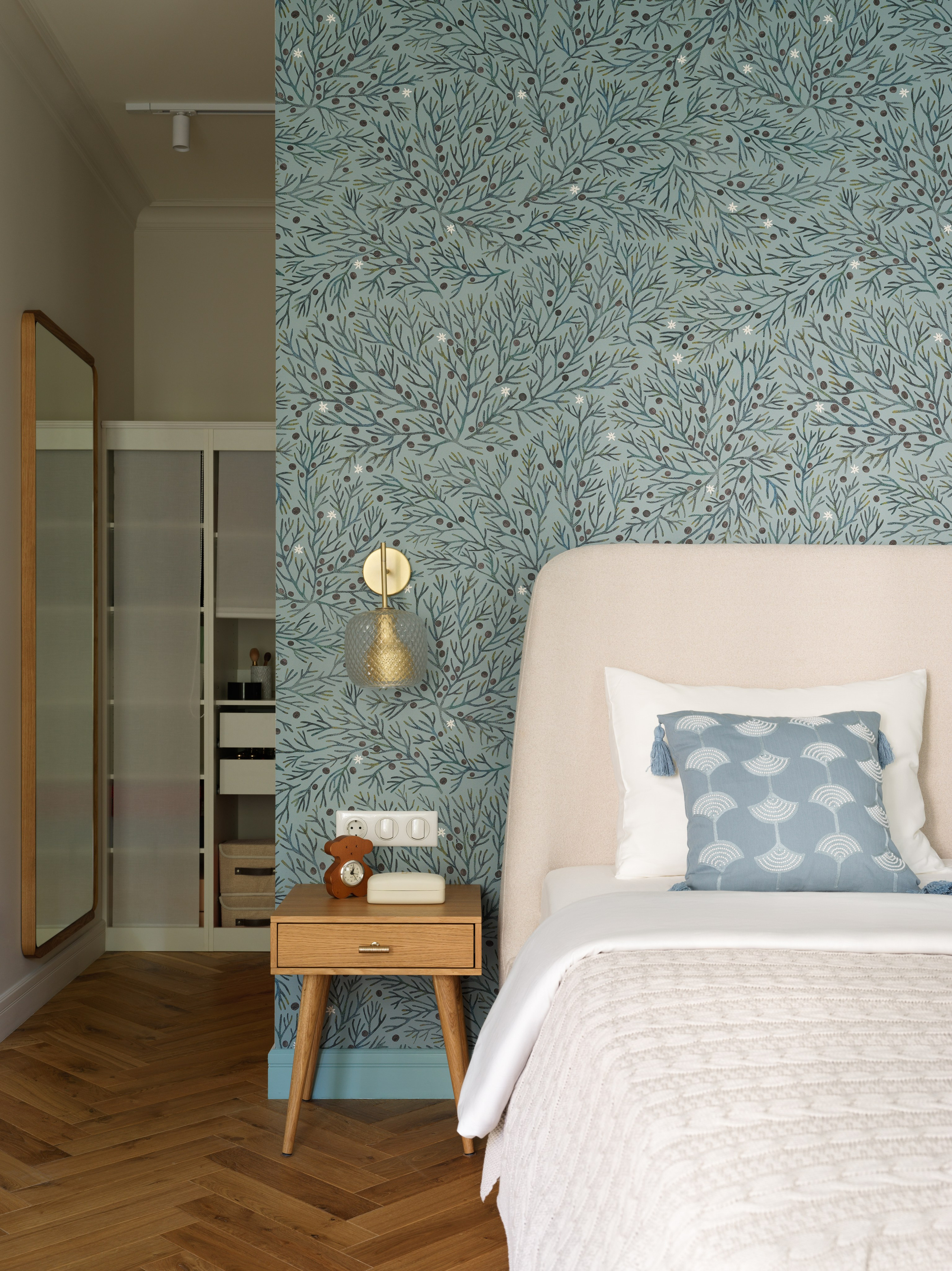 Кровать с высоким мягким изголовьем в центре композиции.