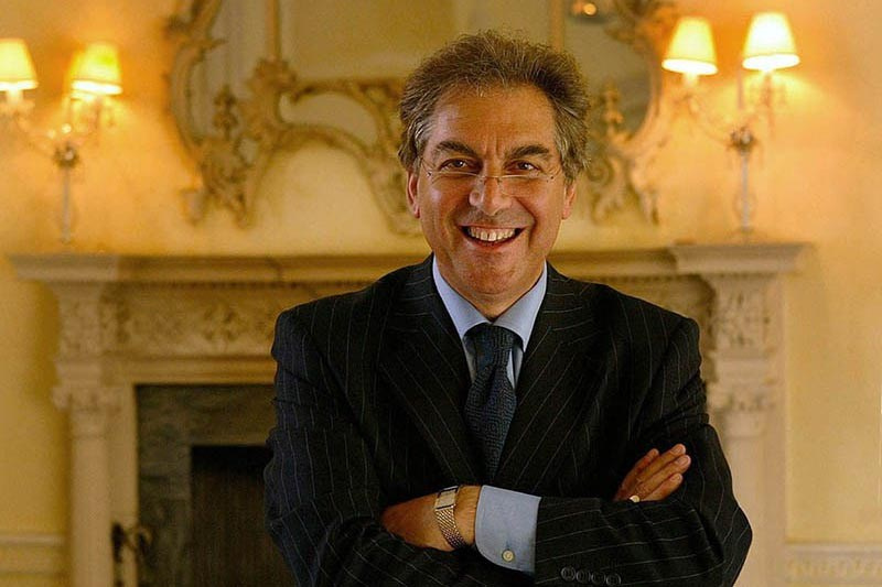 A smiling gentleman poses in front of a historic fireplace during his executive headshot session.