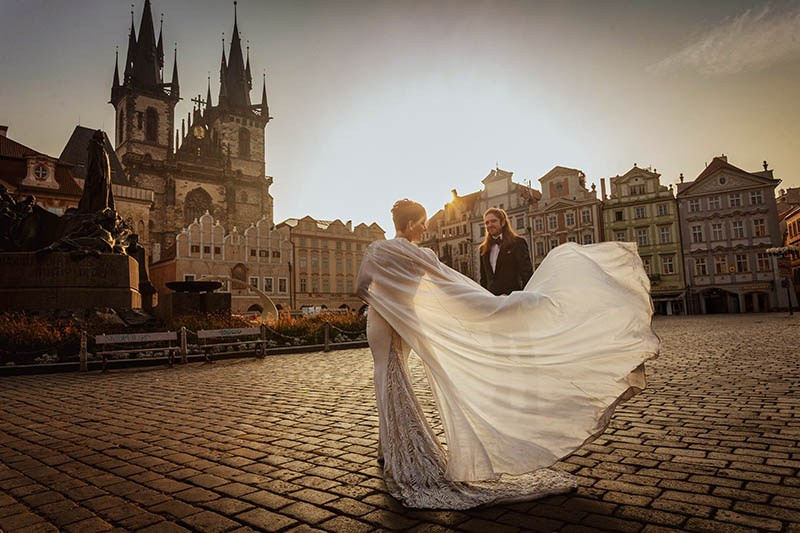 Bride in the $25,000 wedding dress with cape in the Old Town Square in Prague.