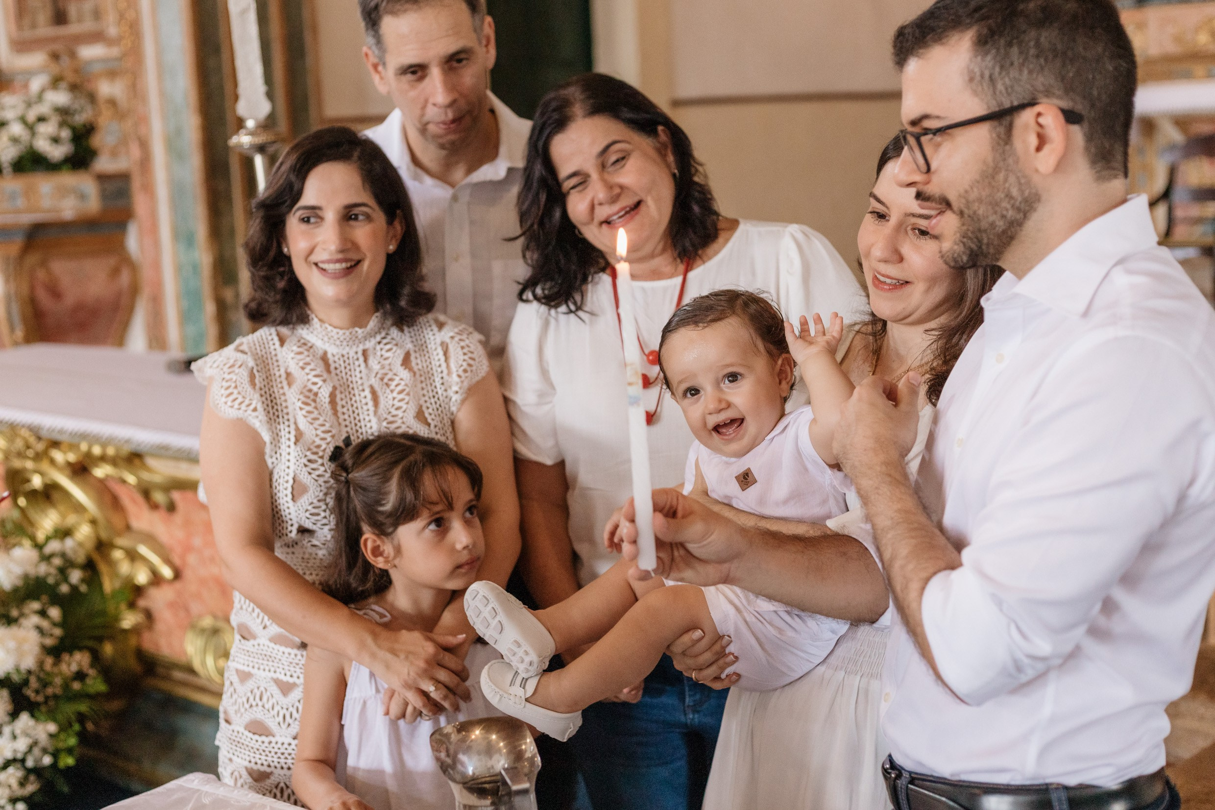 Fotografia de batizado com família reunida durante a celebração