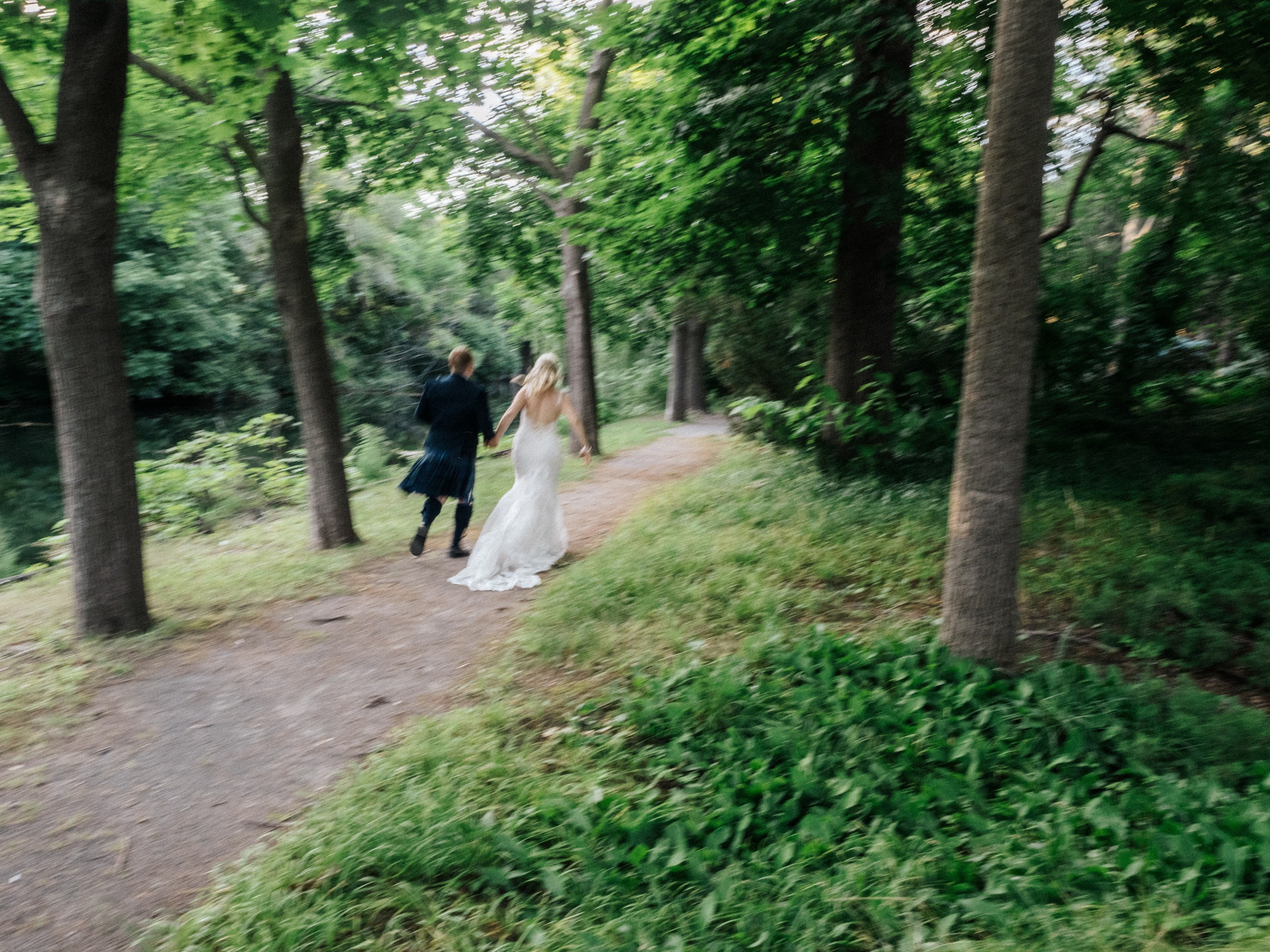 Couple running in the forest, captured with intentional motion blur by Montreal wedding photographer Muriel Oé