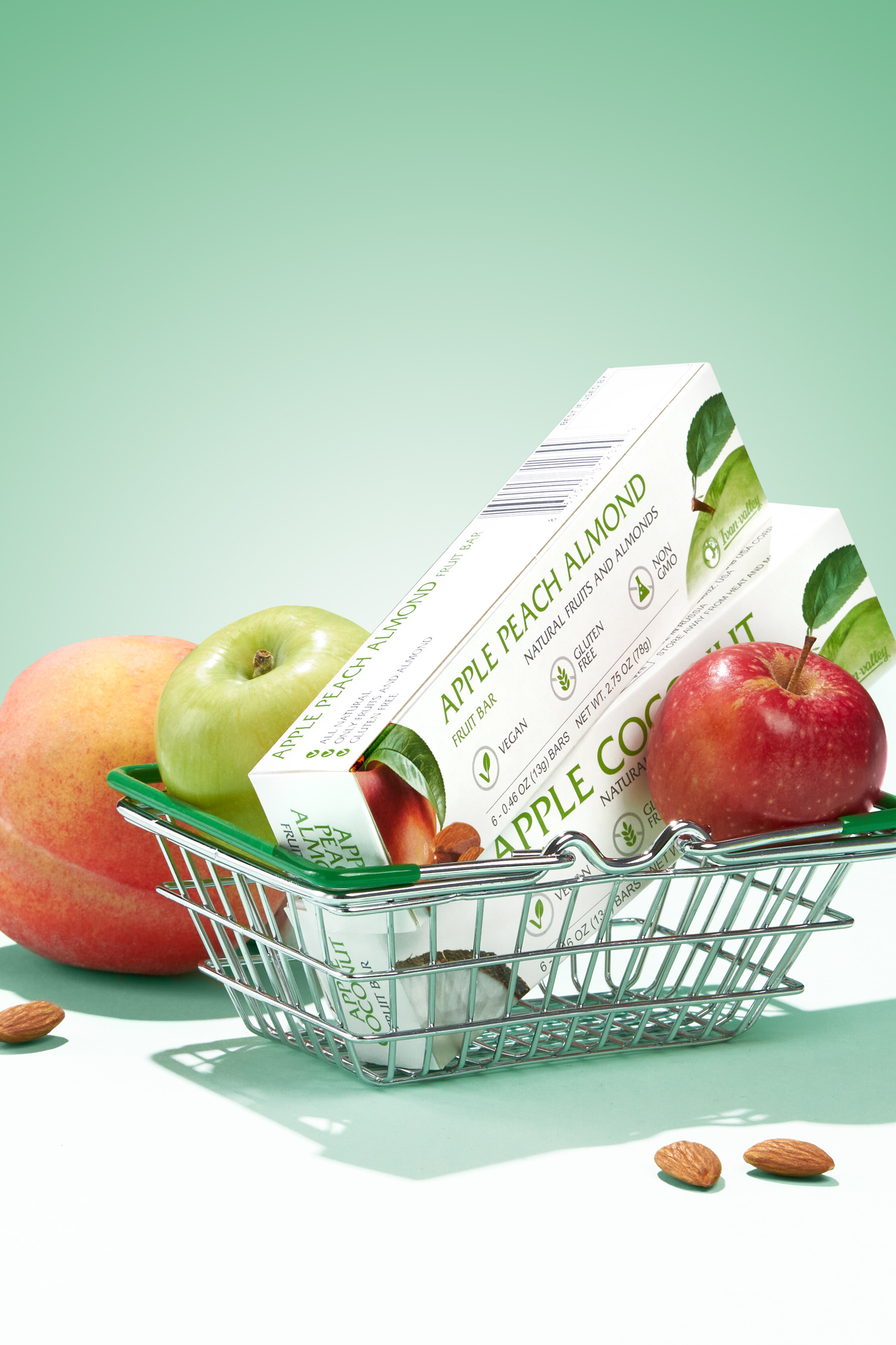 Фотография продукта зубной пасты на светло-зеленом фоне в мини-тележке в окружении красных и зеленых яблок, продвижение услуг ретушера фотографий