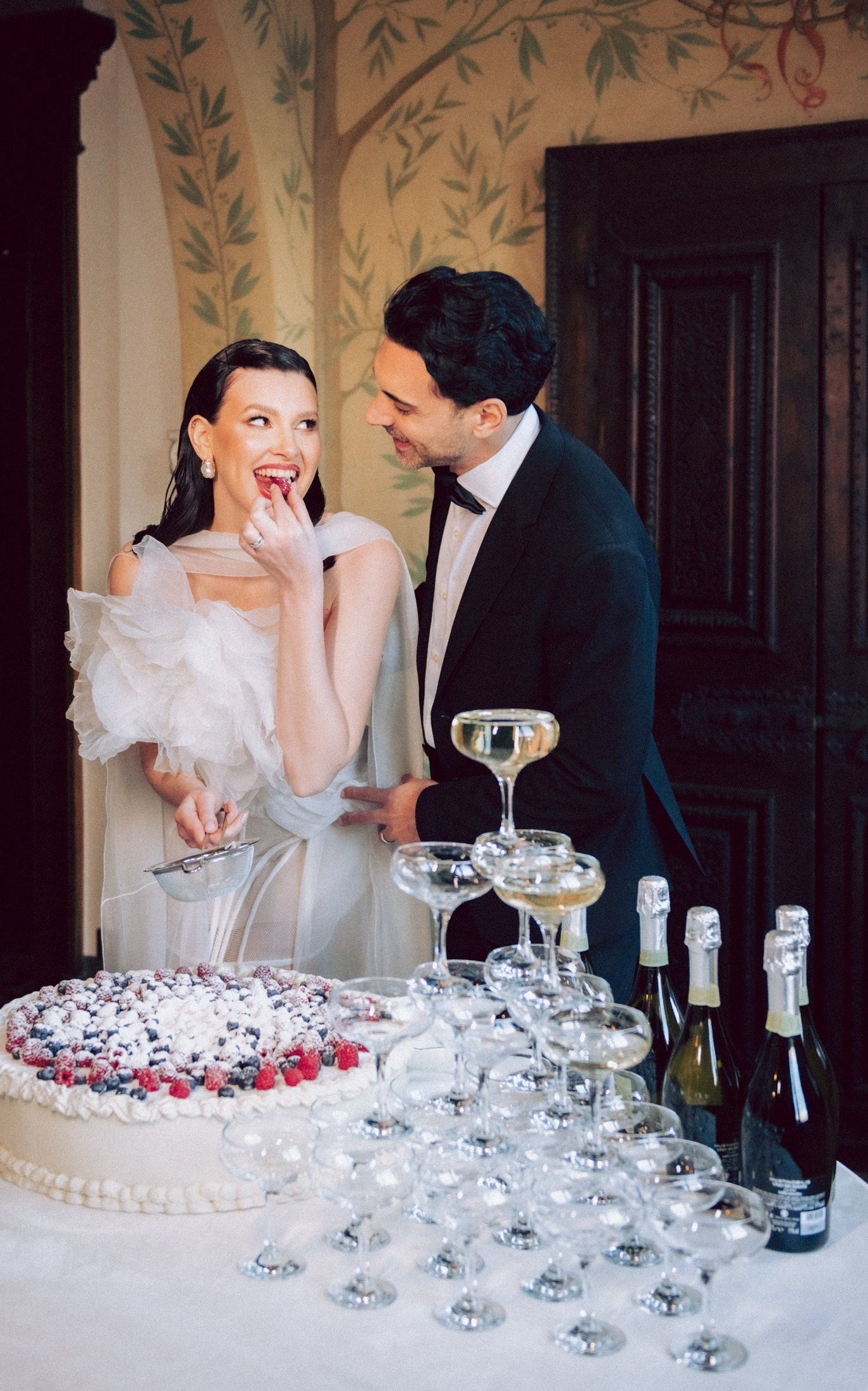Bride and groom celebrating with wedding cake during an elegant destination wedding reception in Italy. Lake Como wedding photographer