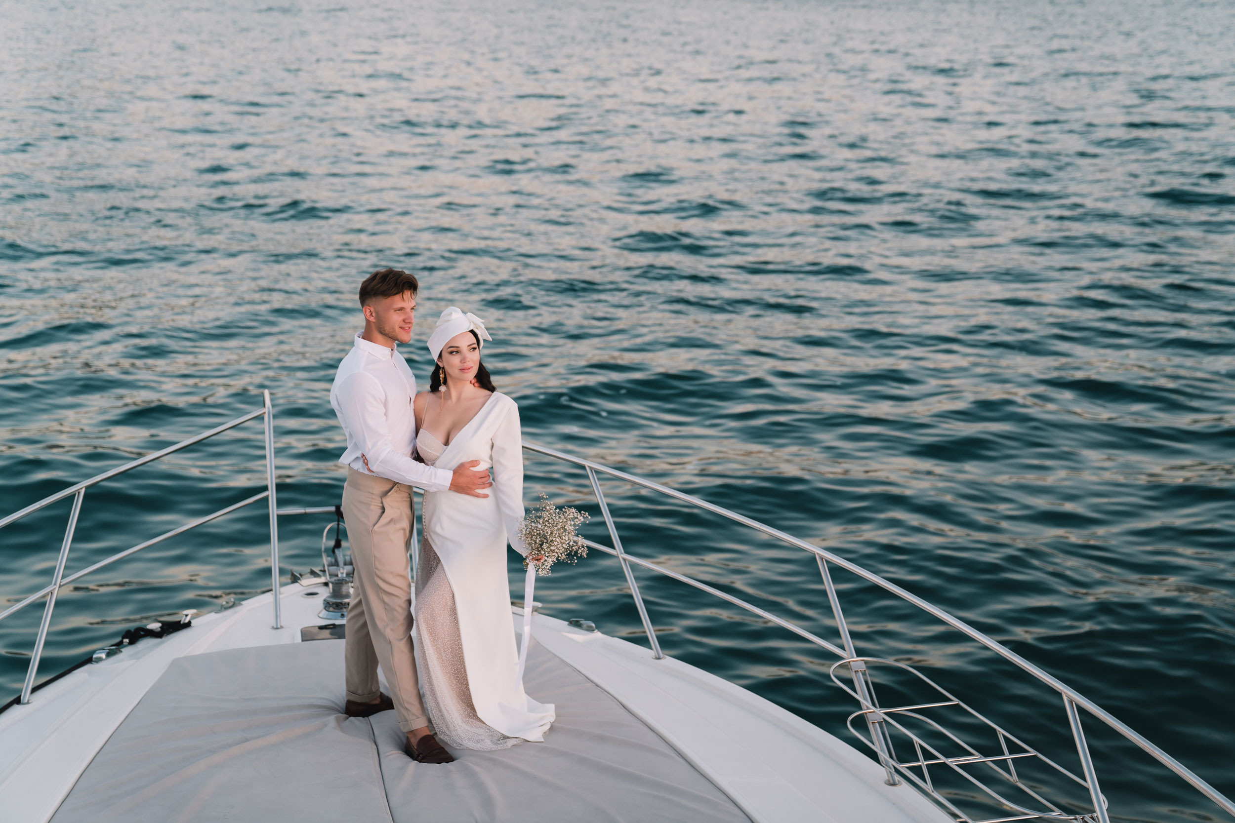 wedding ceremony with bride and groom kissing each other on a yacht