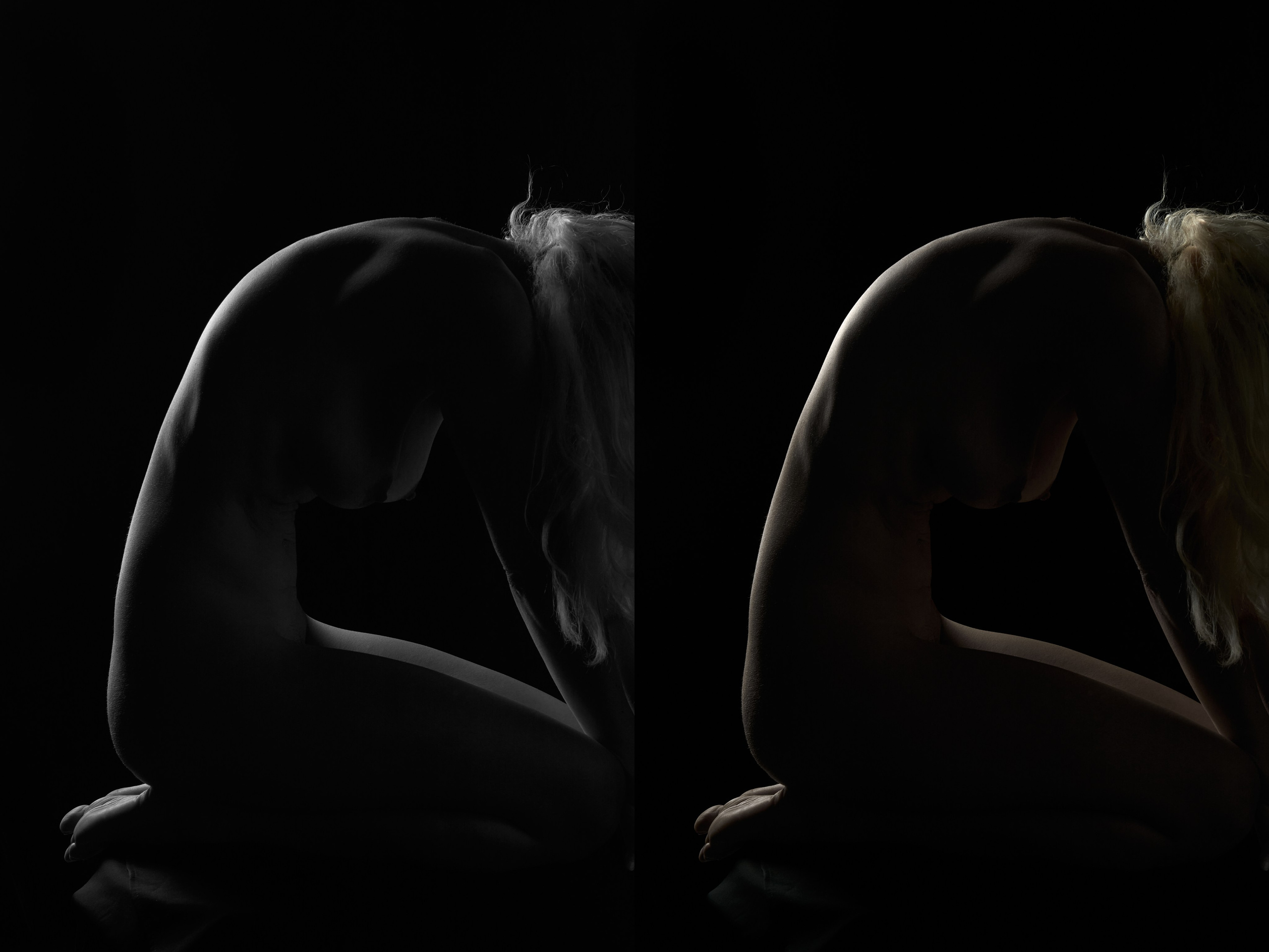 Nude silhouette emerging from darkness in monochrome and color photography